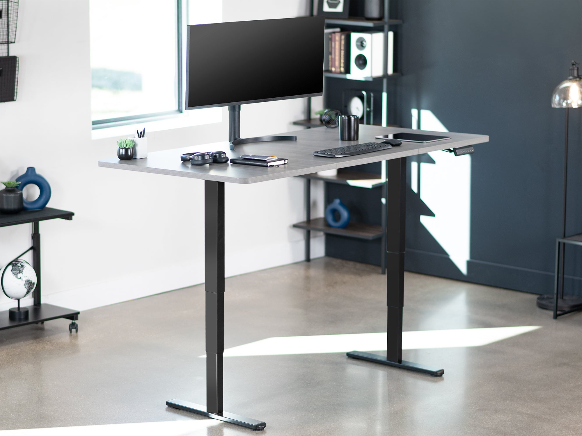 Gray and black electric standing desk in home office setting