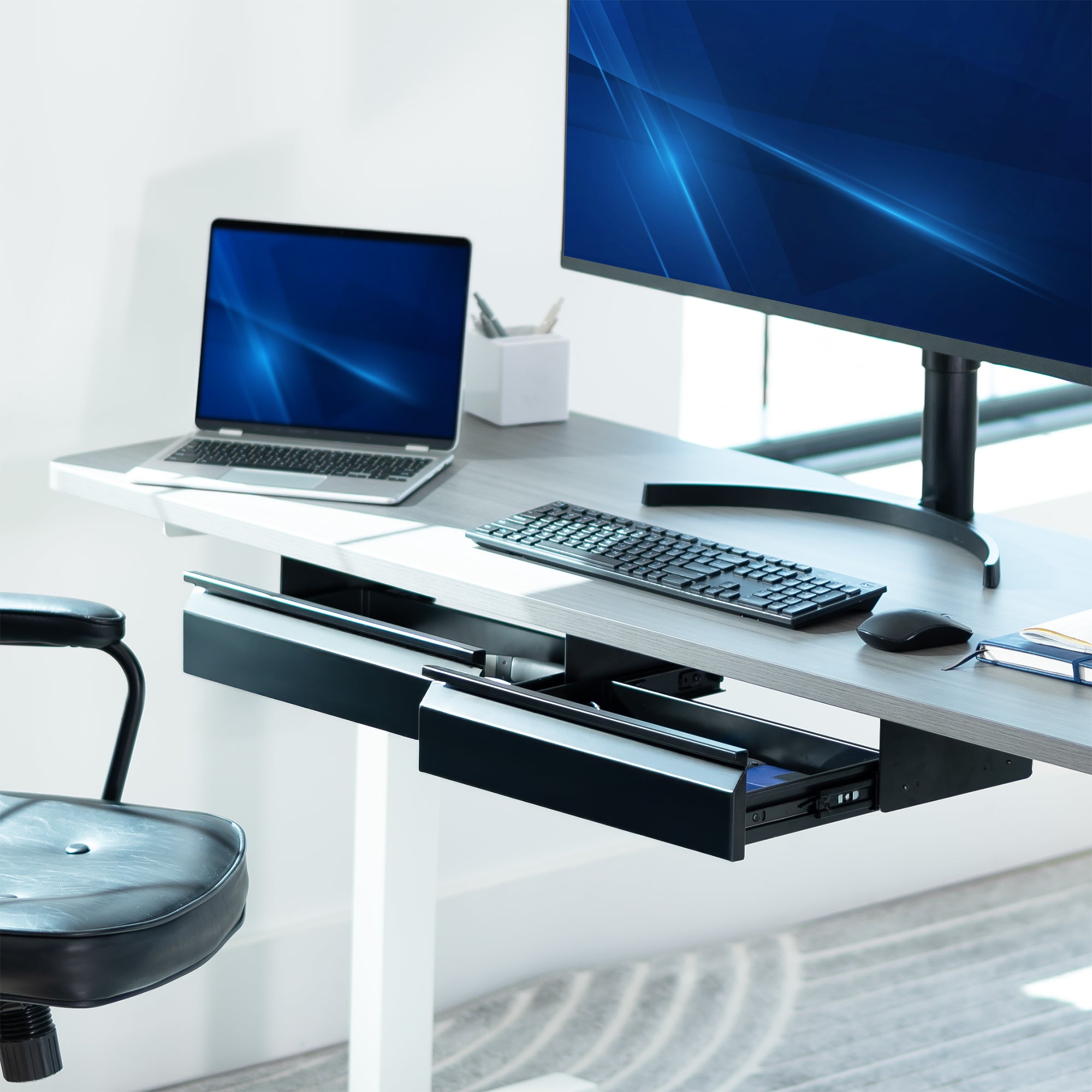 Modern office desk setup with laptop, monitor, keyboard, and mouse on a white background
