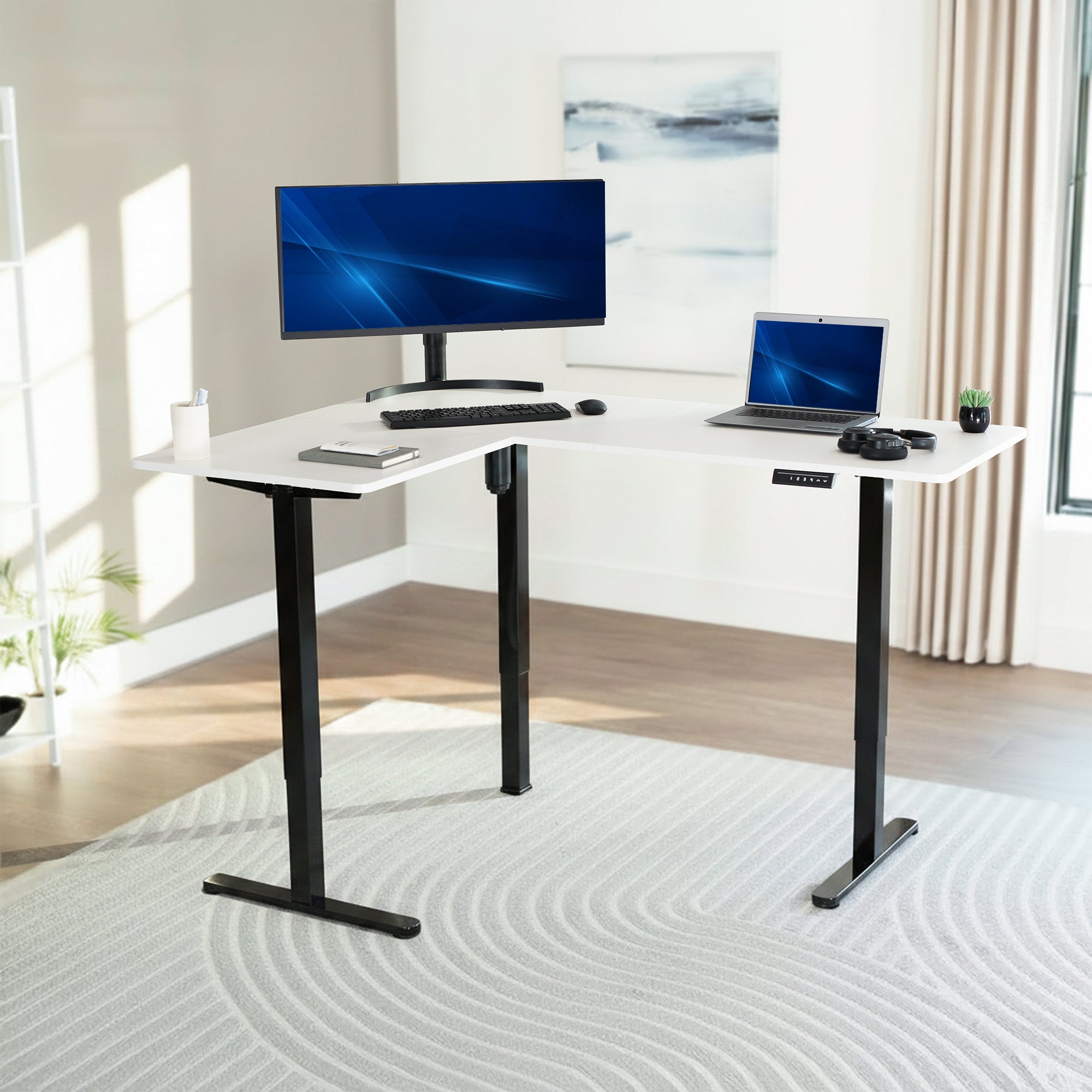 White adjustable desk with computer setup in a bright room