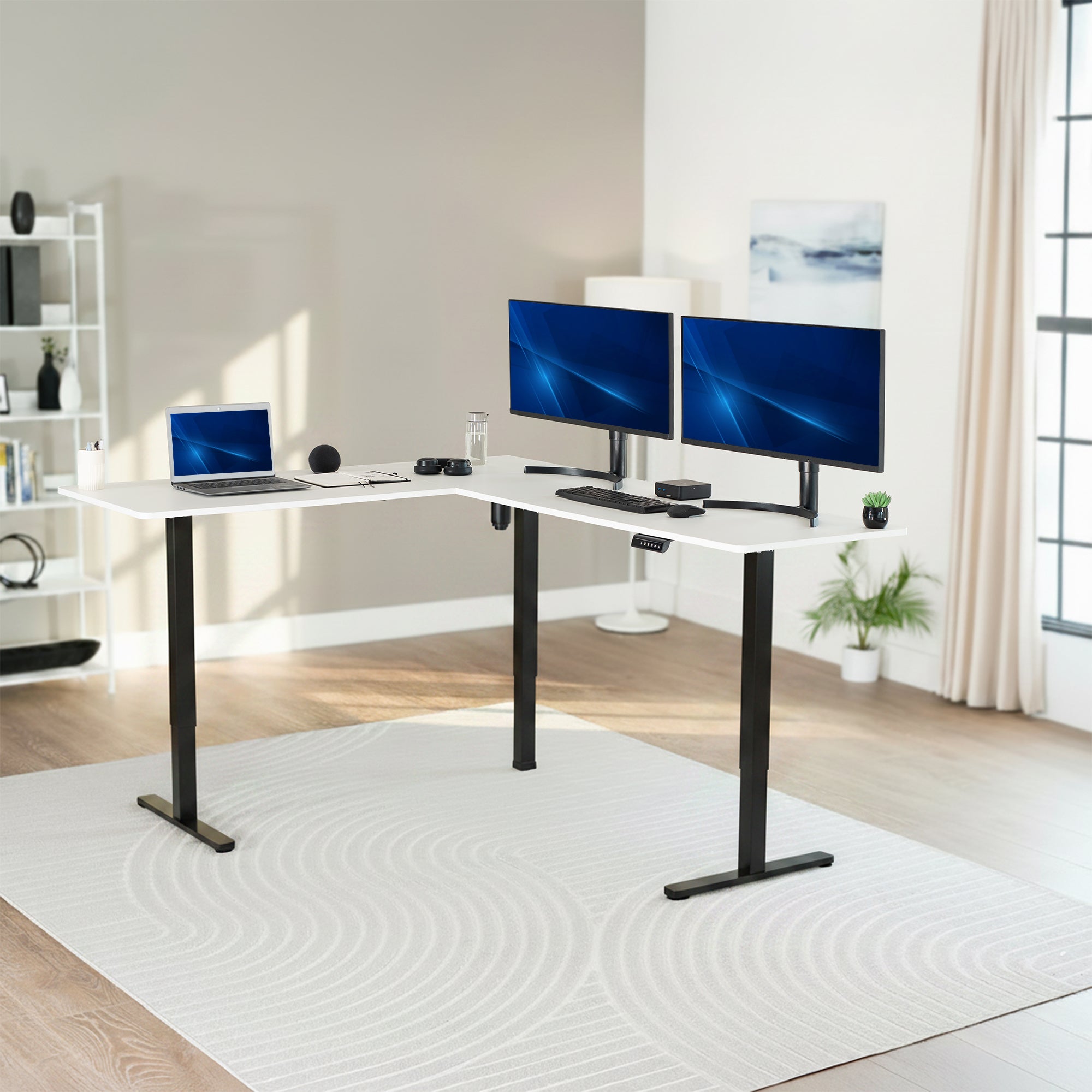 Modern home office with a white L-shaped desk, laptop, and two monitors.