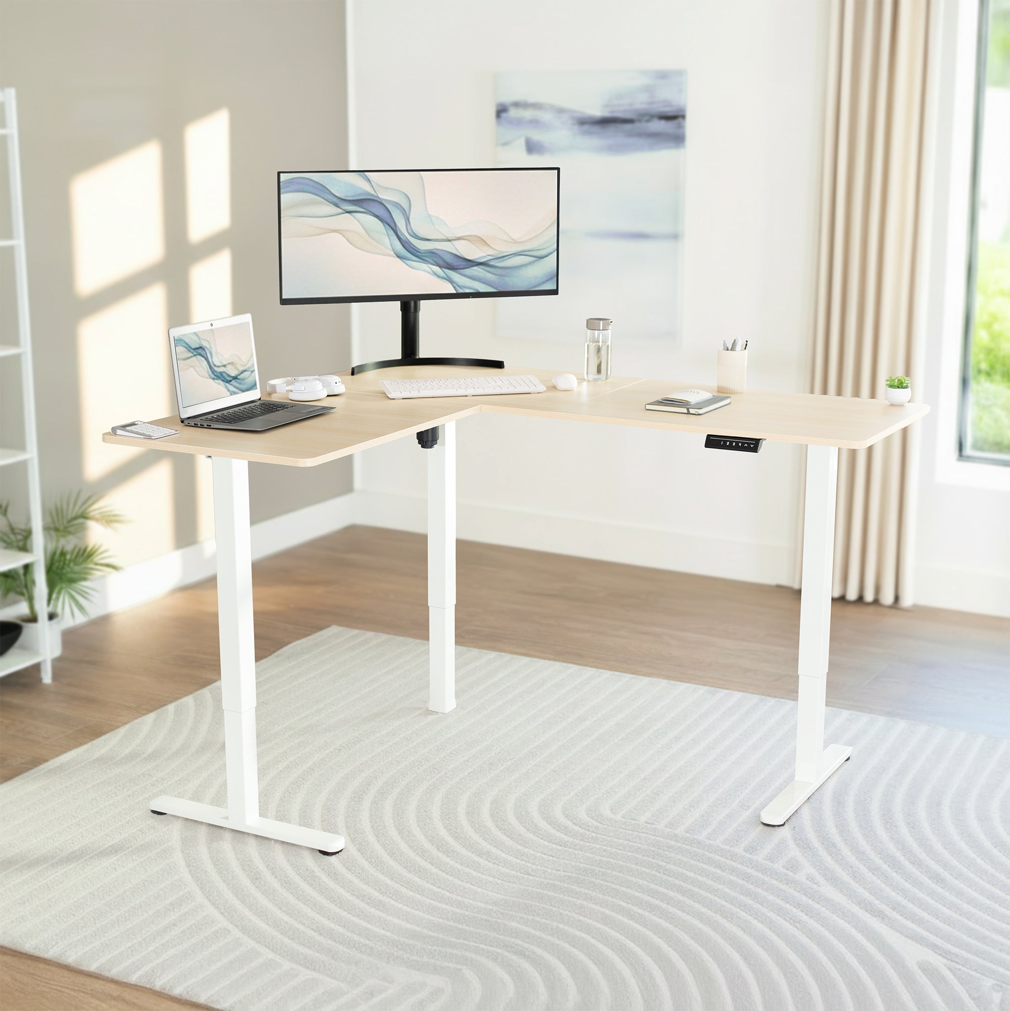 Modern home office setup with a adjustable desk, computer monitor, and laptop.