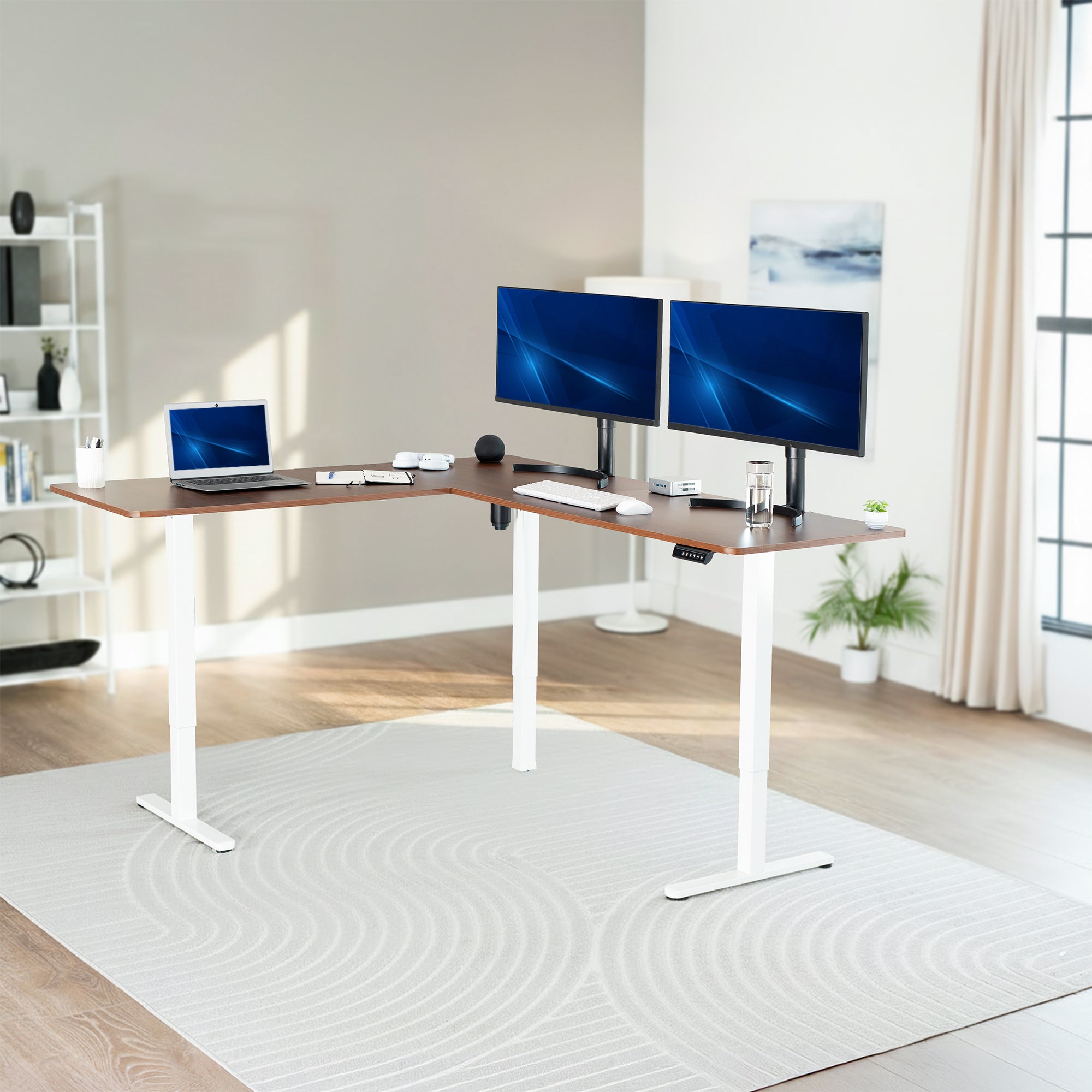 Modern home office with a adjustable L-shaped desk, two monitors, and a laptop.