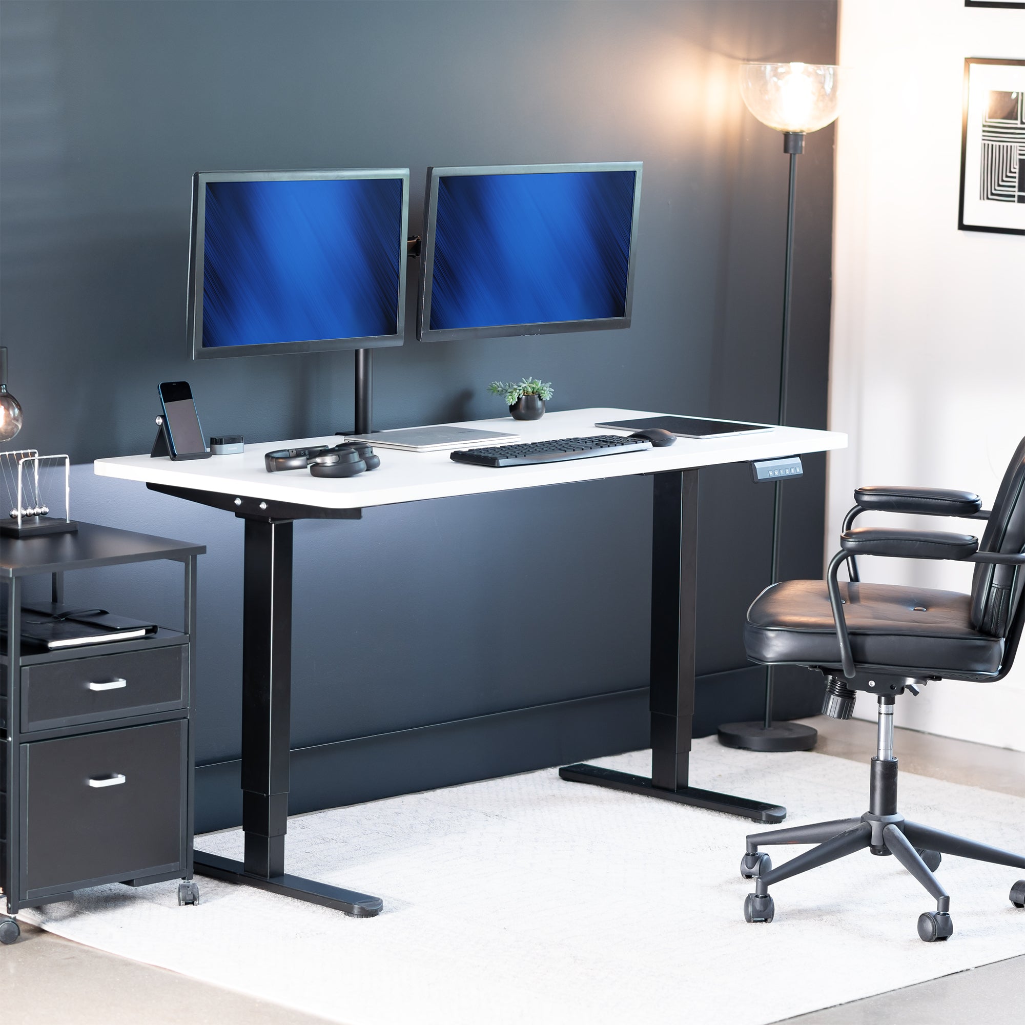 Modern office setup with a white desk, black chair, and two monitors.