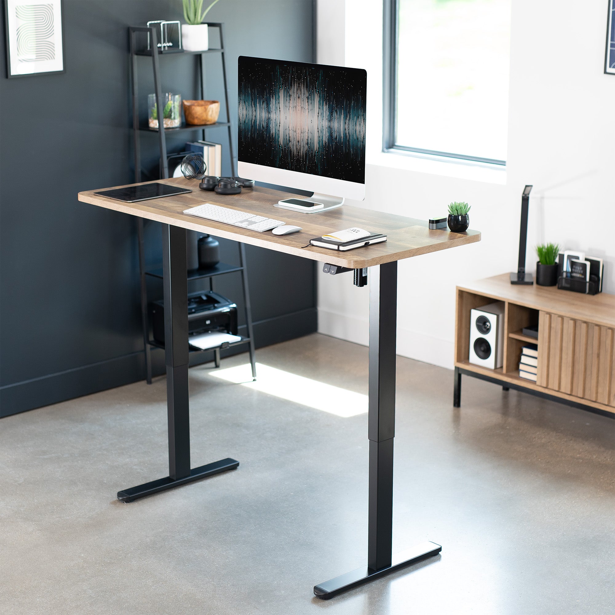 Modern office setup with a standing desk, computer monitor, and office furniture.
