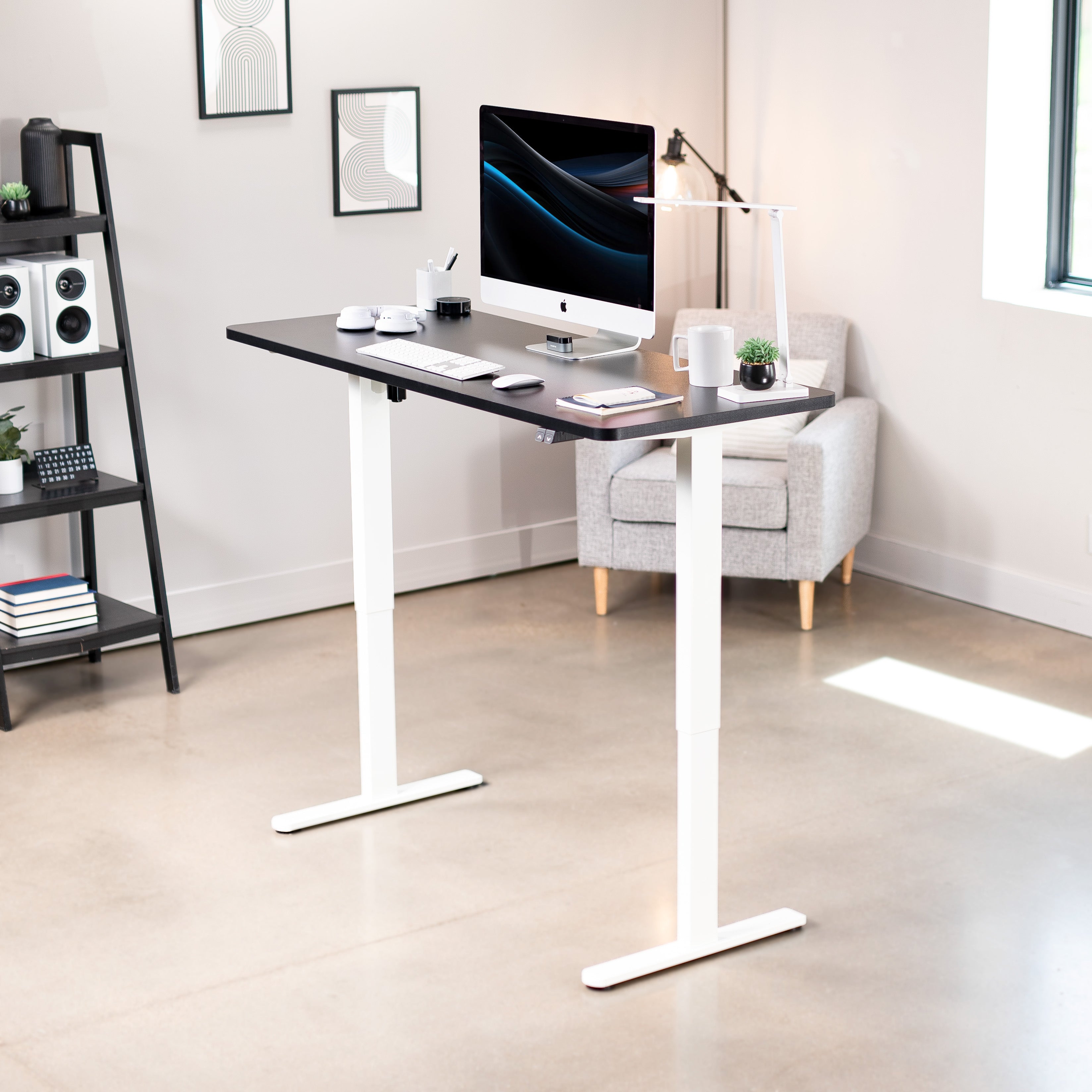 Modern office setup with a standing desk, computer monitor, and chair.