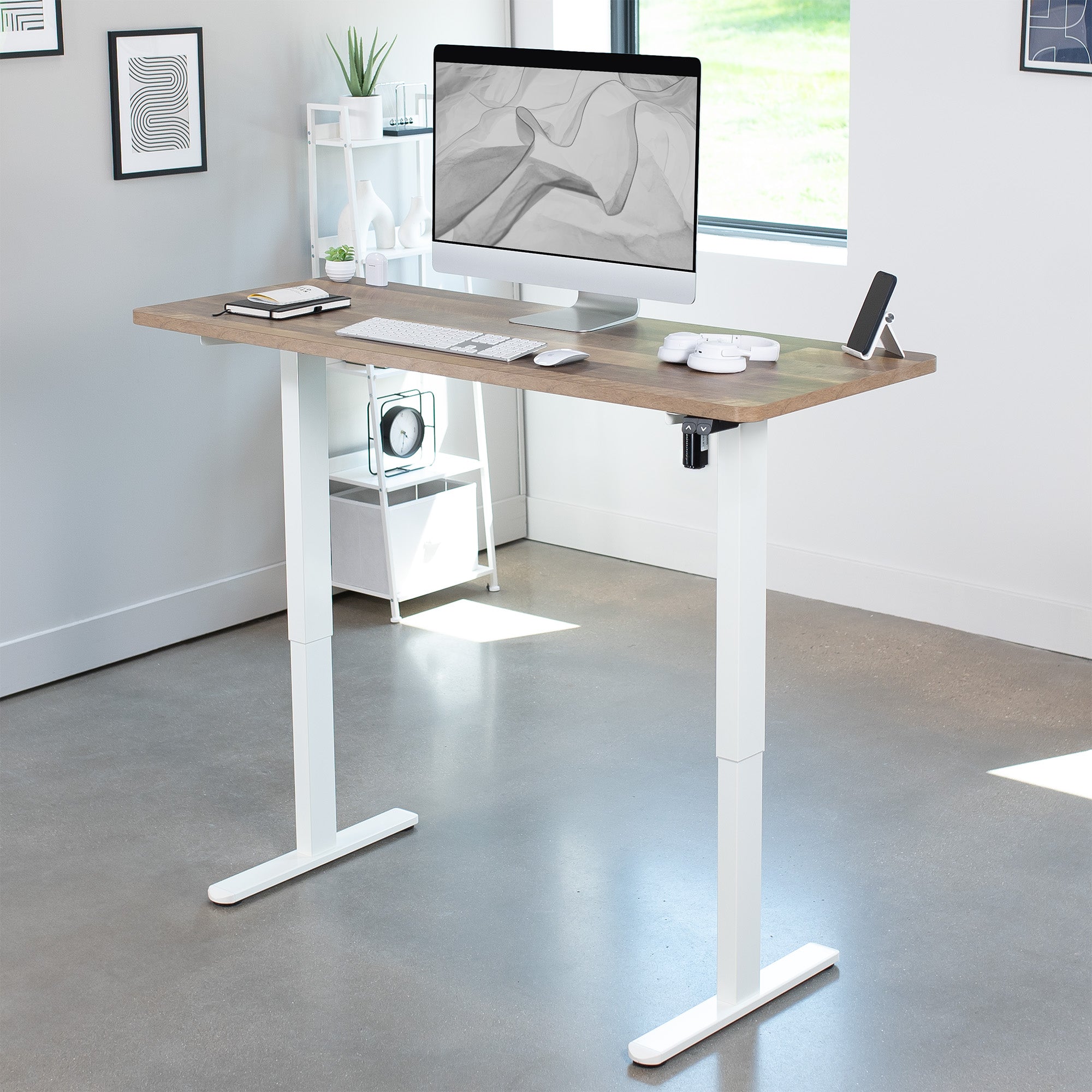 Adjustable height desk with a computer setup in a home office.