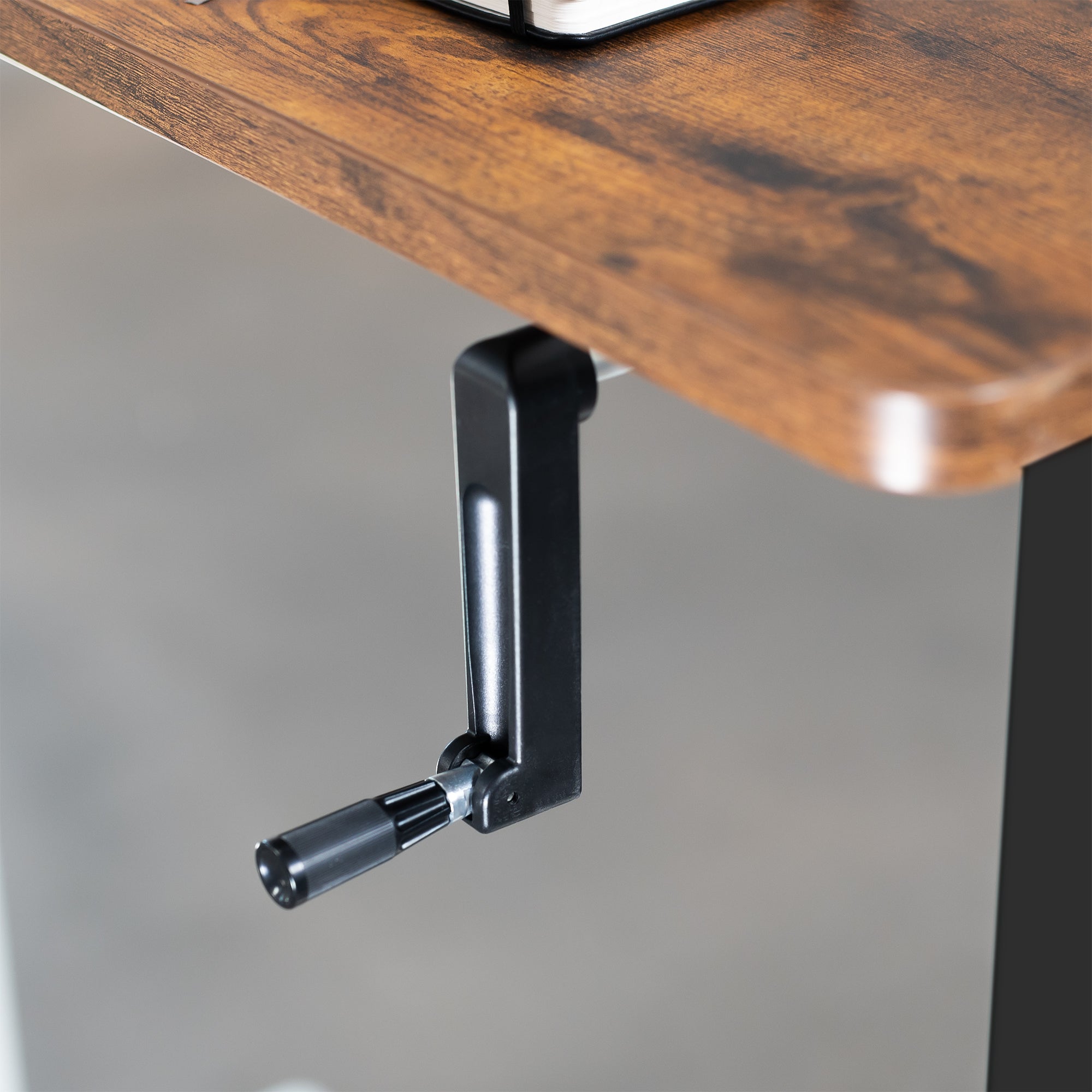 Compact steel desk frame with brown desktop and a dual monitor mount.