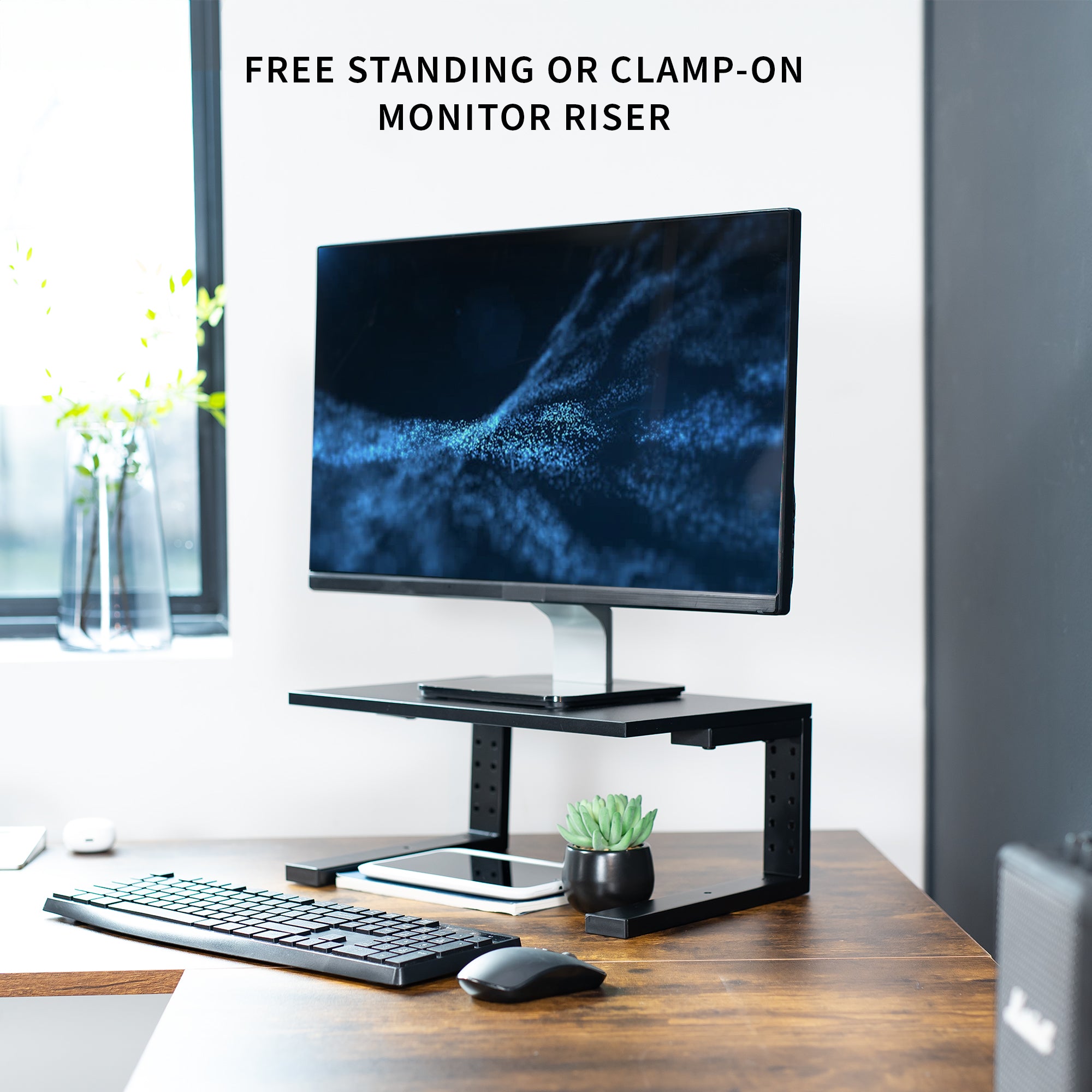 Computer monitor on a stand with keyboard and mouse on a desk, featuring text about monitor riser options.