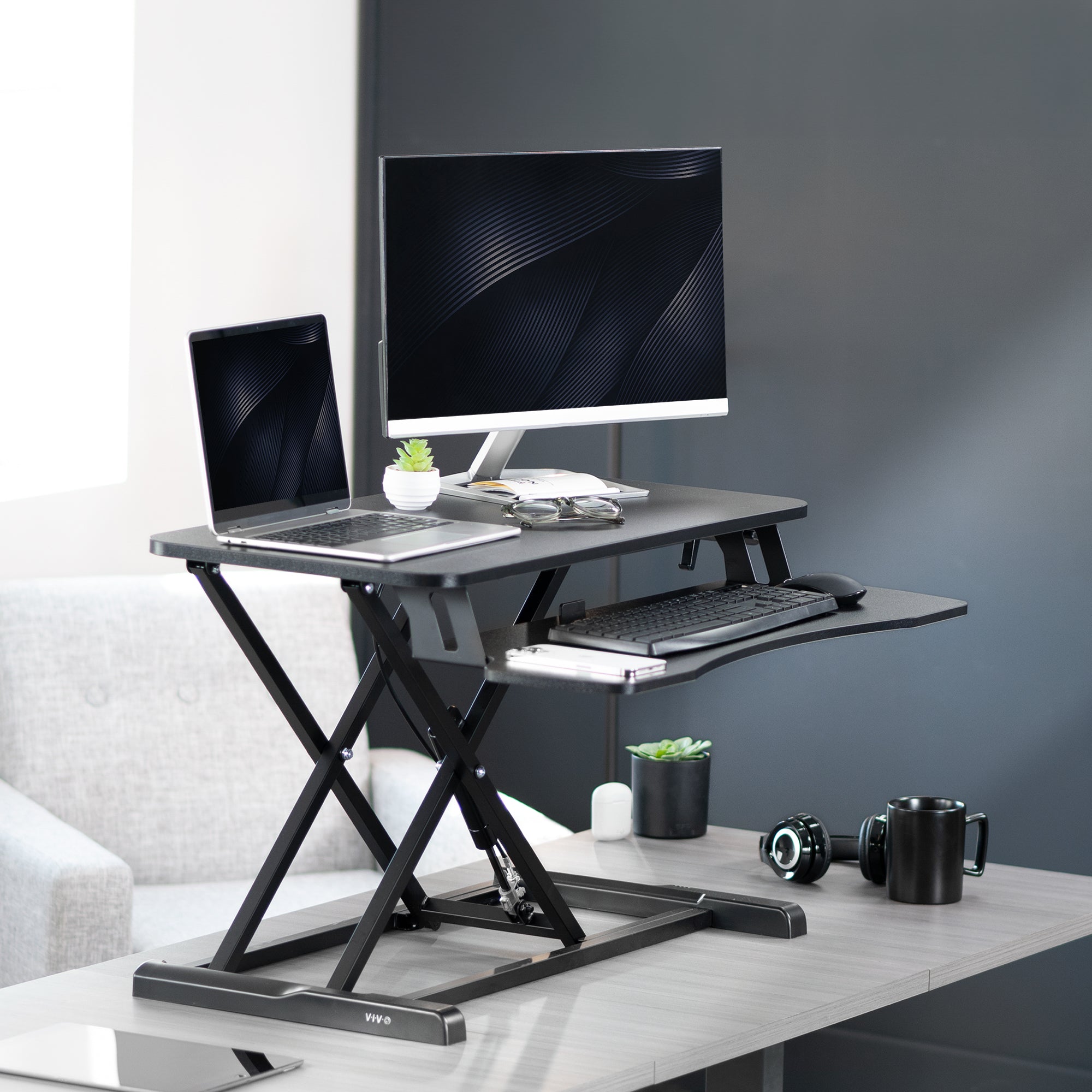 Sturdy height adjustable 2-tiered desk riser for ergonomic office workstation in office setting.