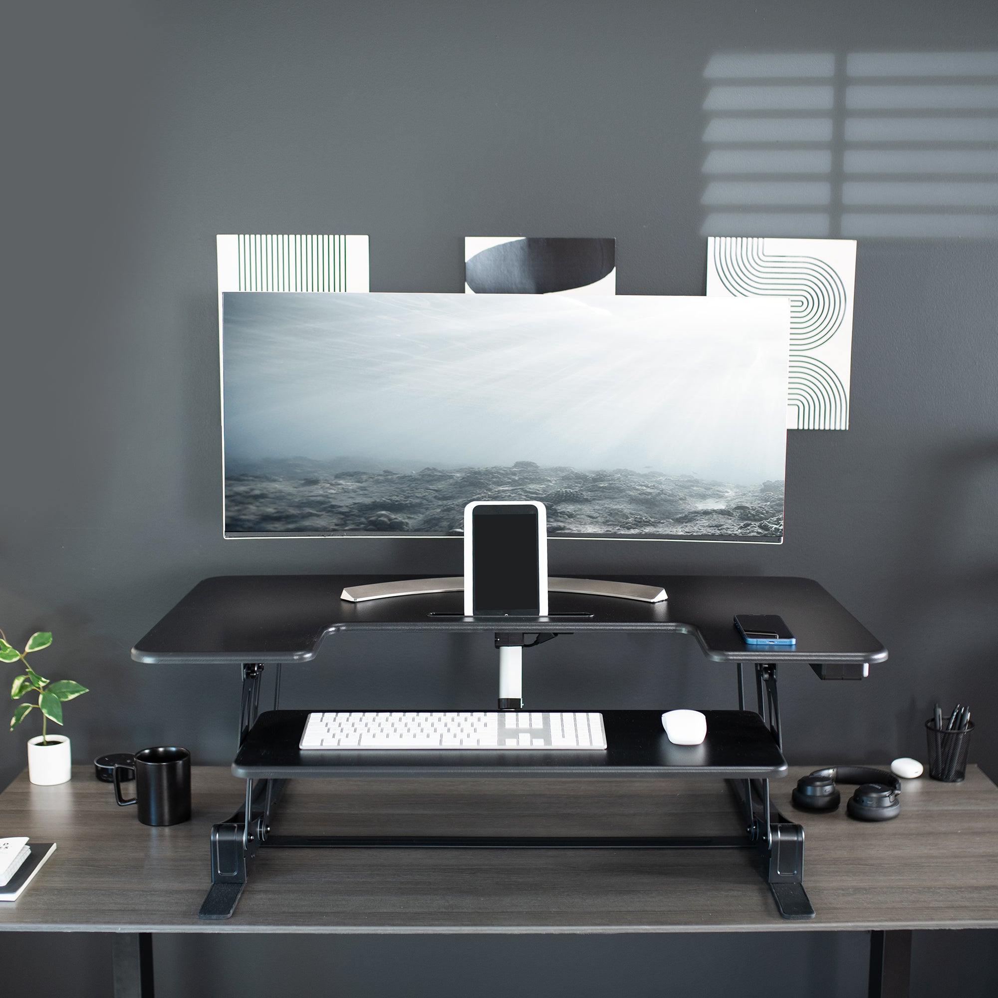 Dual-tiered, electric desk riser that sits on top of your current desk and gives you the benefit of standing up throughout the work day.