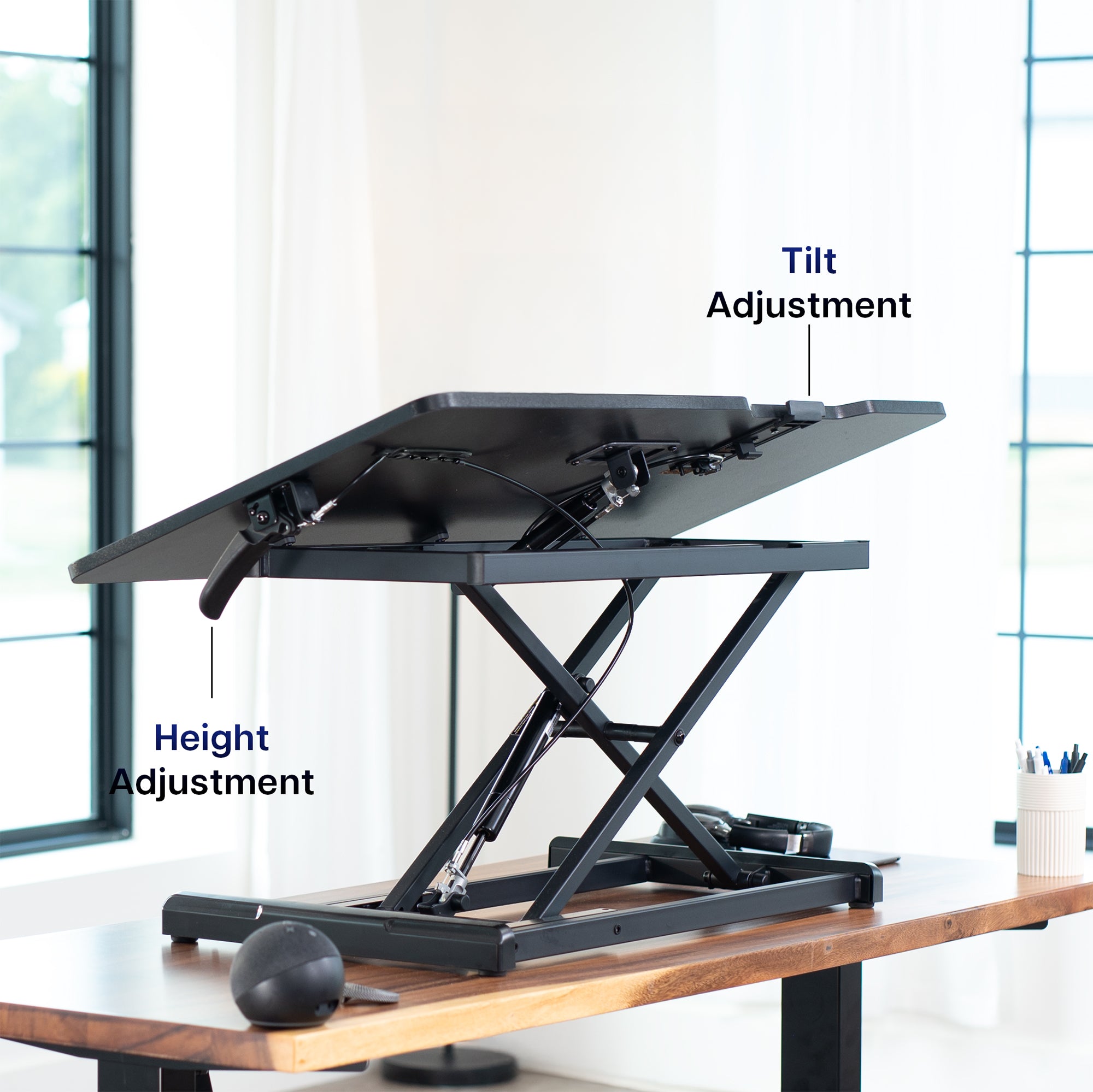 Adjustable standing desk with height and tilt adjustment labels in a home office setting.