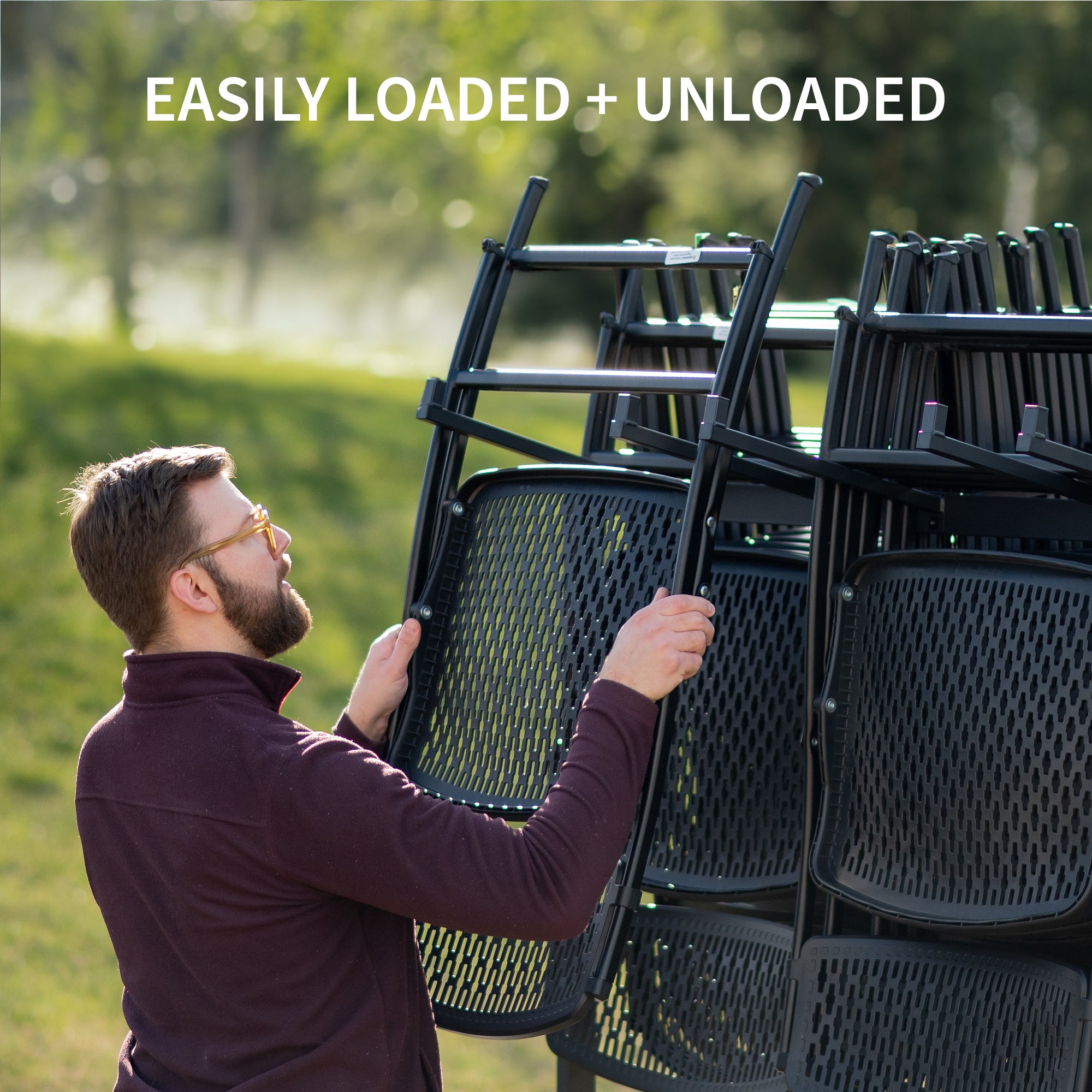 Man loading black chairs onto a vehicle with text.