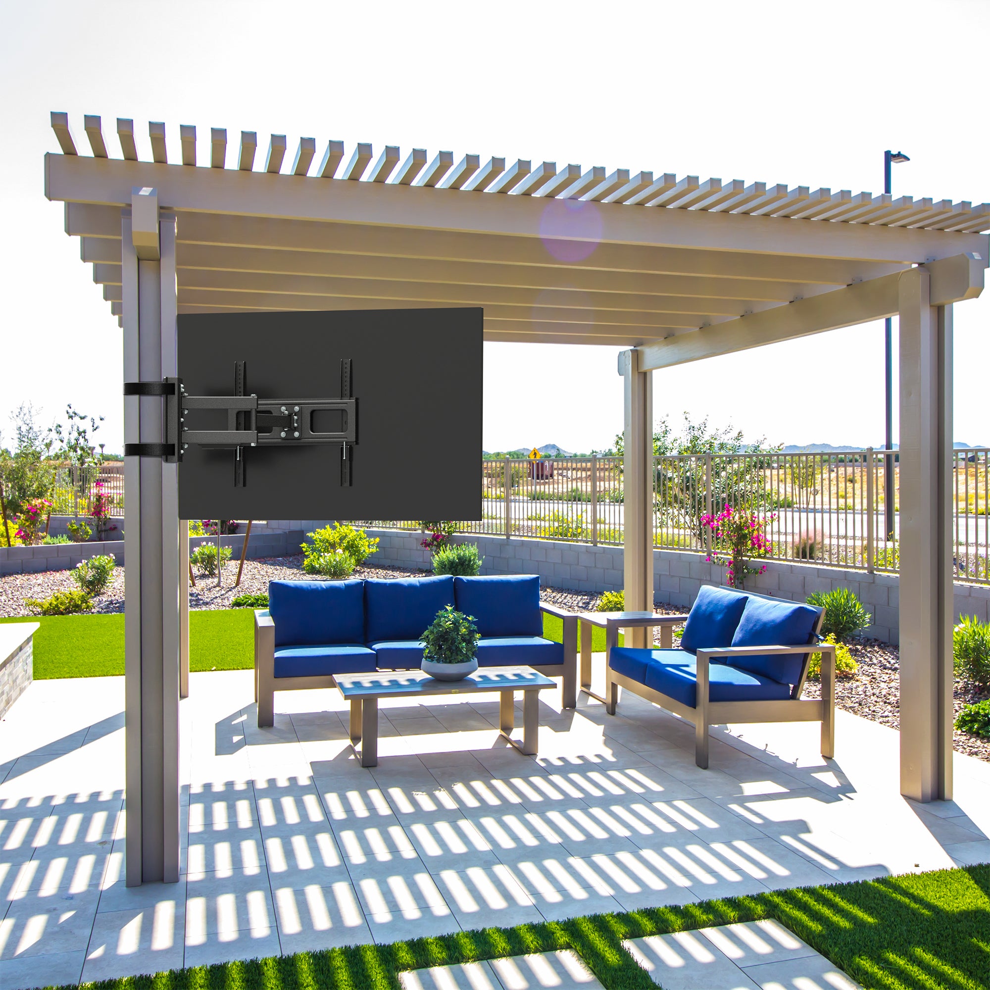 Outdoor patio with pergola, blue furniture, and TV mounted on the wall.