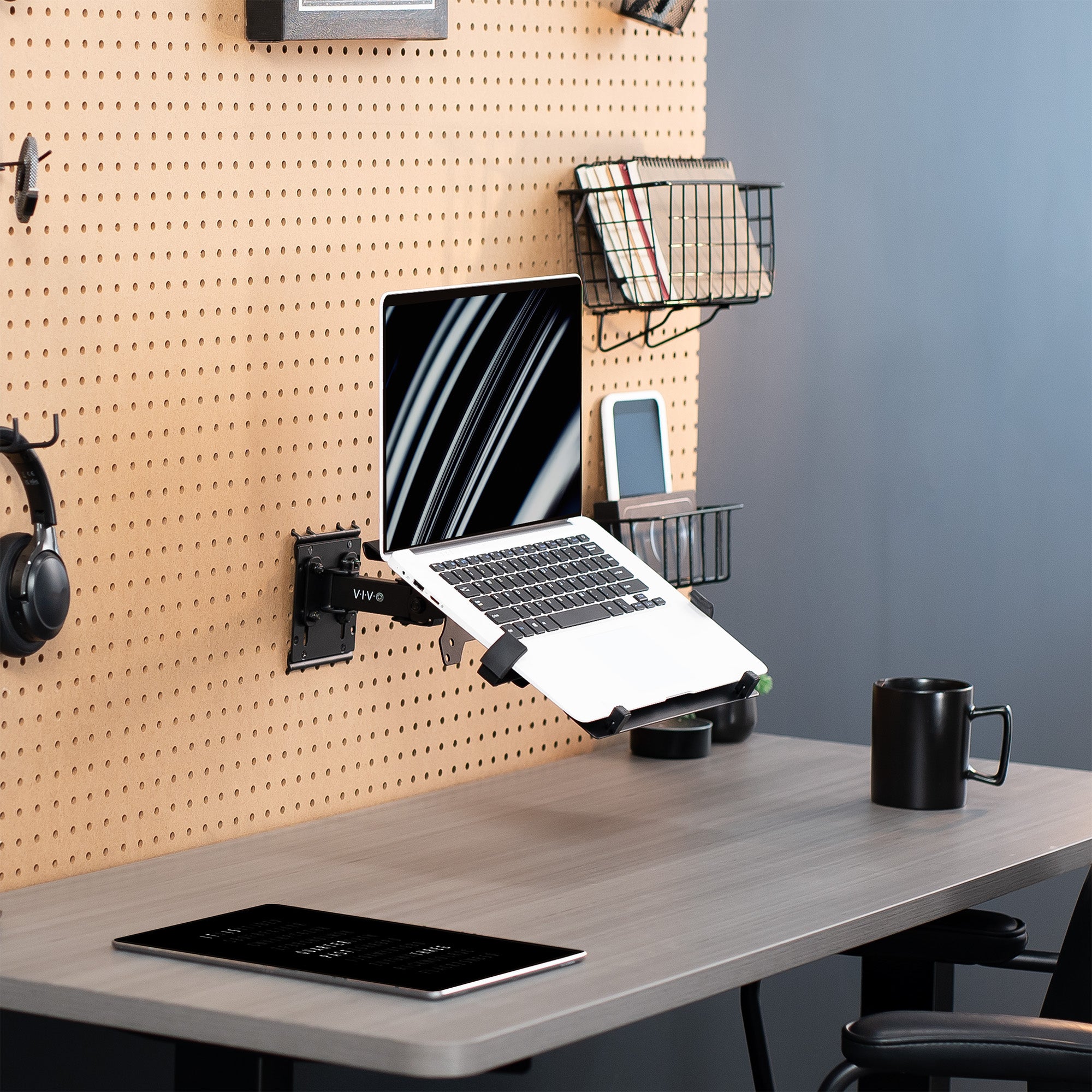 Pegboard mounted laptop tray with articulating arm. Featuring adjustable holder clamps and tray ventilation.