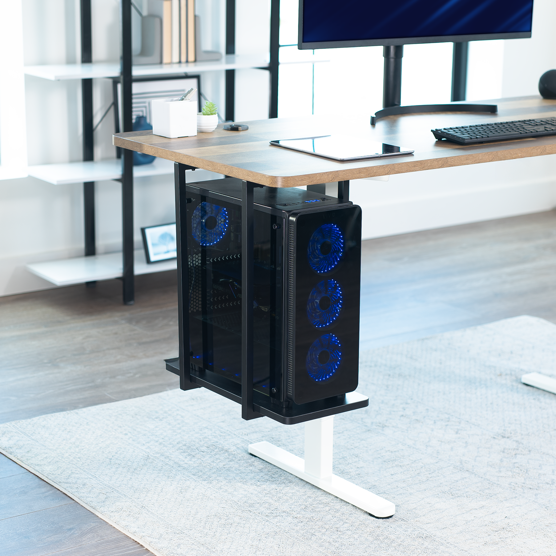 Computer tower on a stand in a home office setting with a desk and monitor.