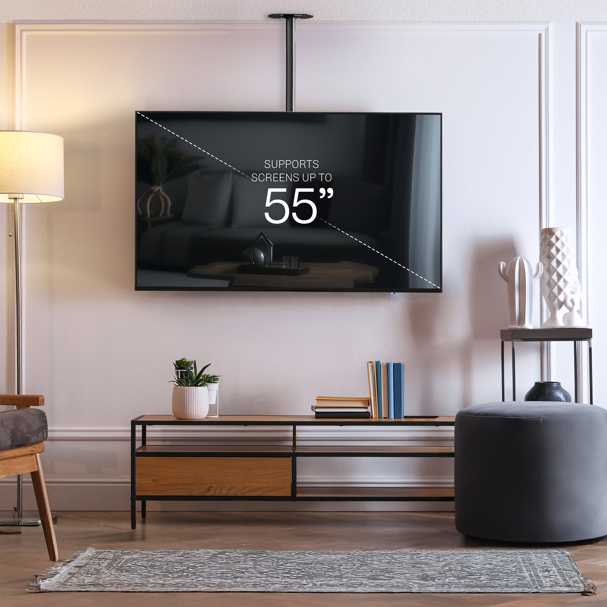 Articulating ceiling TV mount in black color in a modern living room setting.