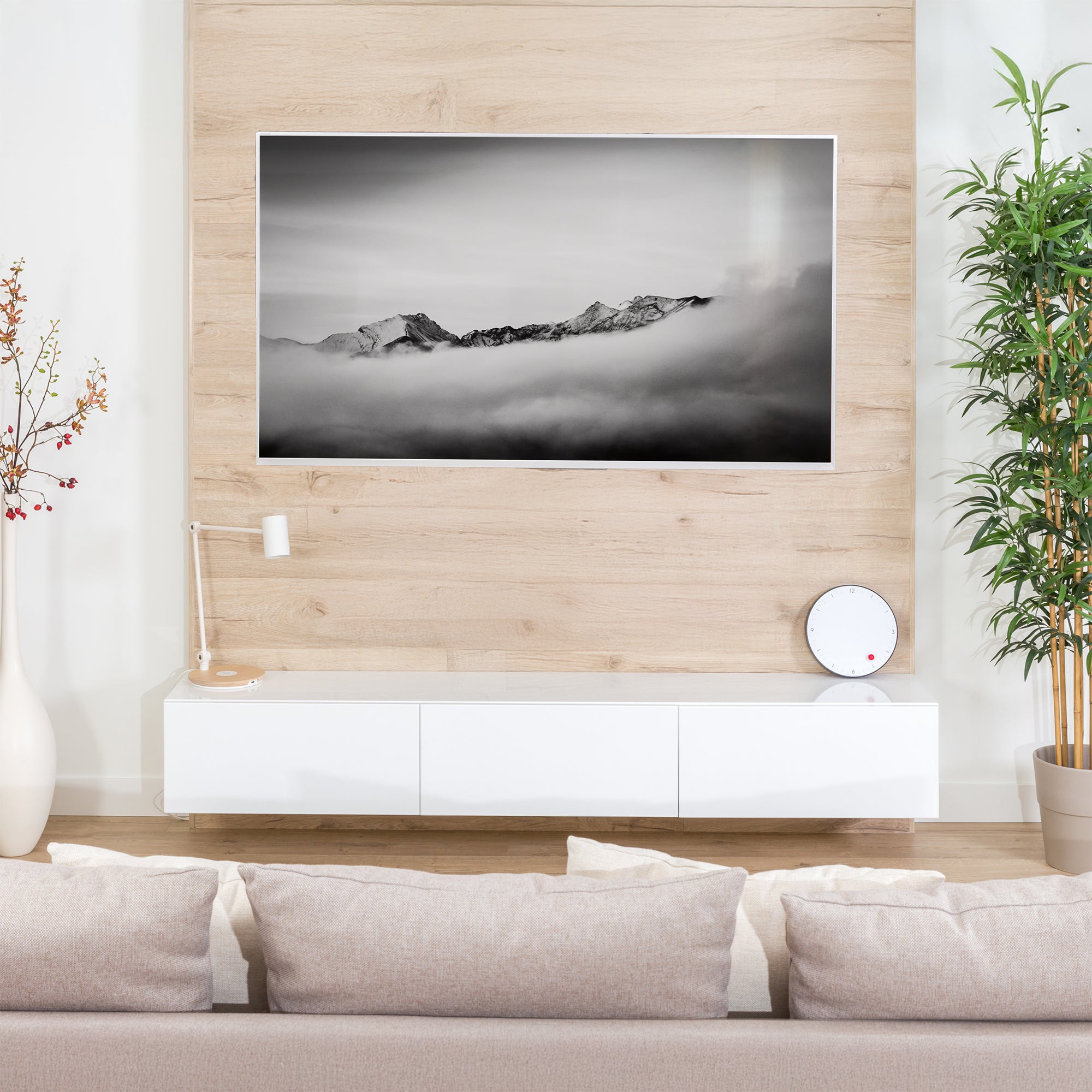 A black VESA wall mount in a living room setting.