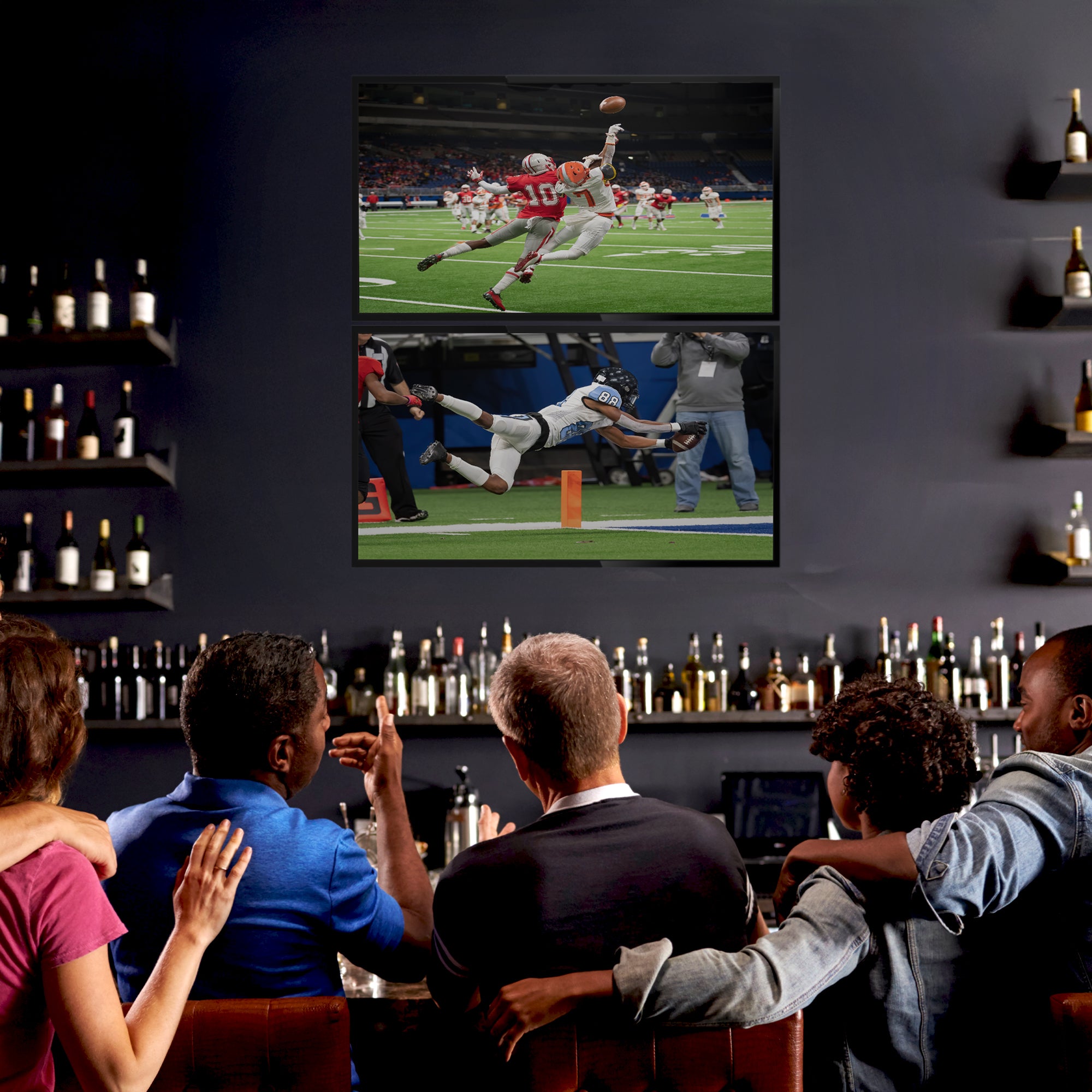 A black TV wall mount holding 2 TVs in a bar scene.
