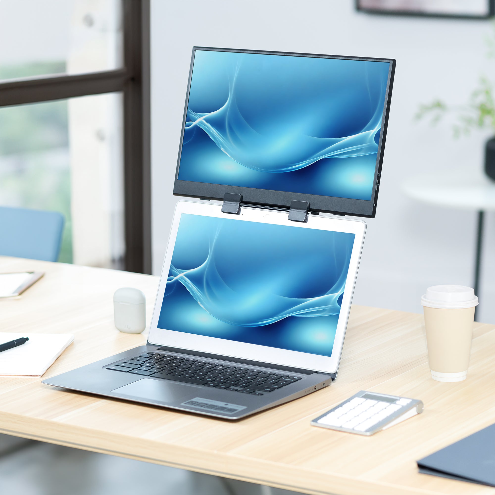 A black portable monitor laptop extension holder in a home office.