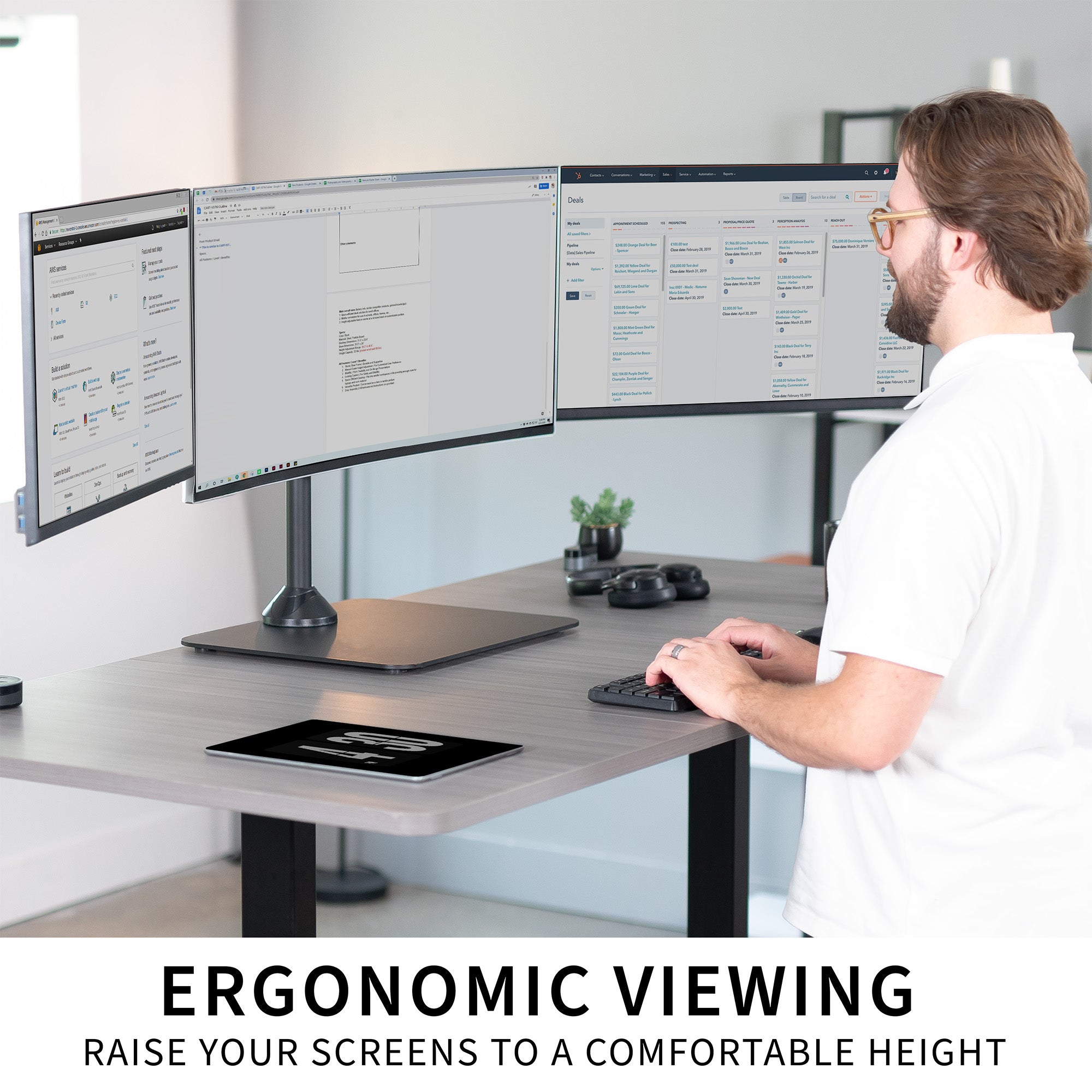 Person using a computer with three monitors at a desk, emphasizing ergonomic viewing.