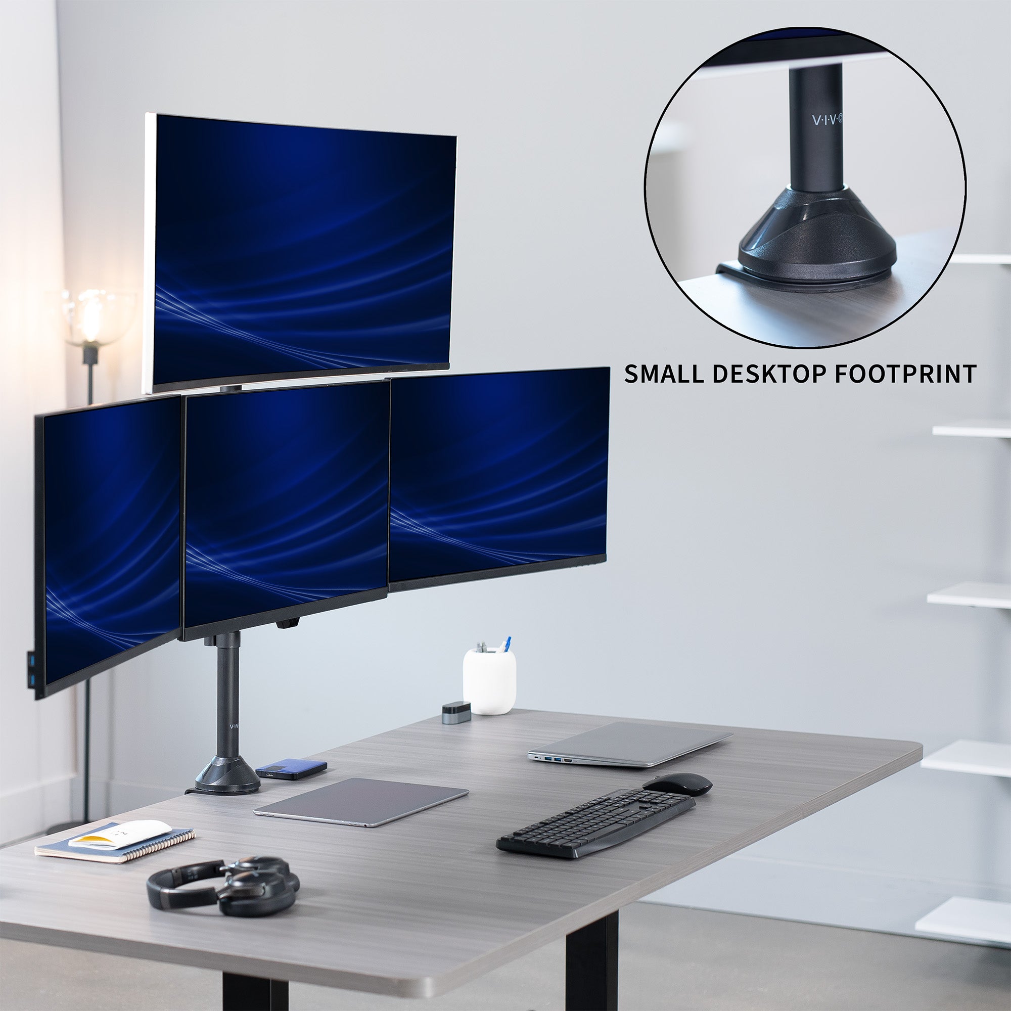 Four computer monitors on a desk with a close-up of the monitor stand labeled.