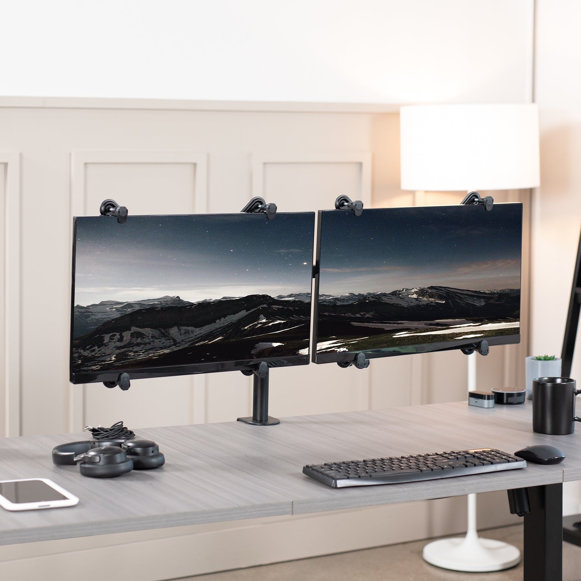 Dual Monitor Desk Mount with VESA Adapter Bracket on desk in office setting.