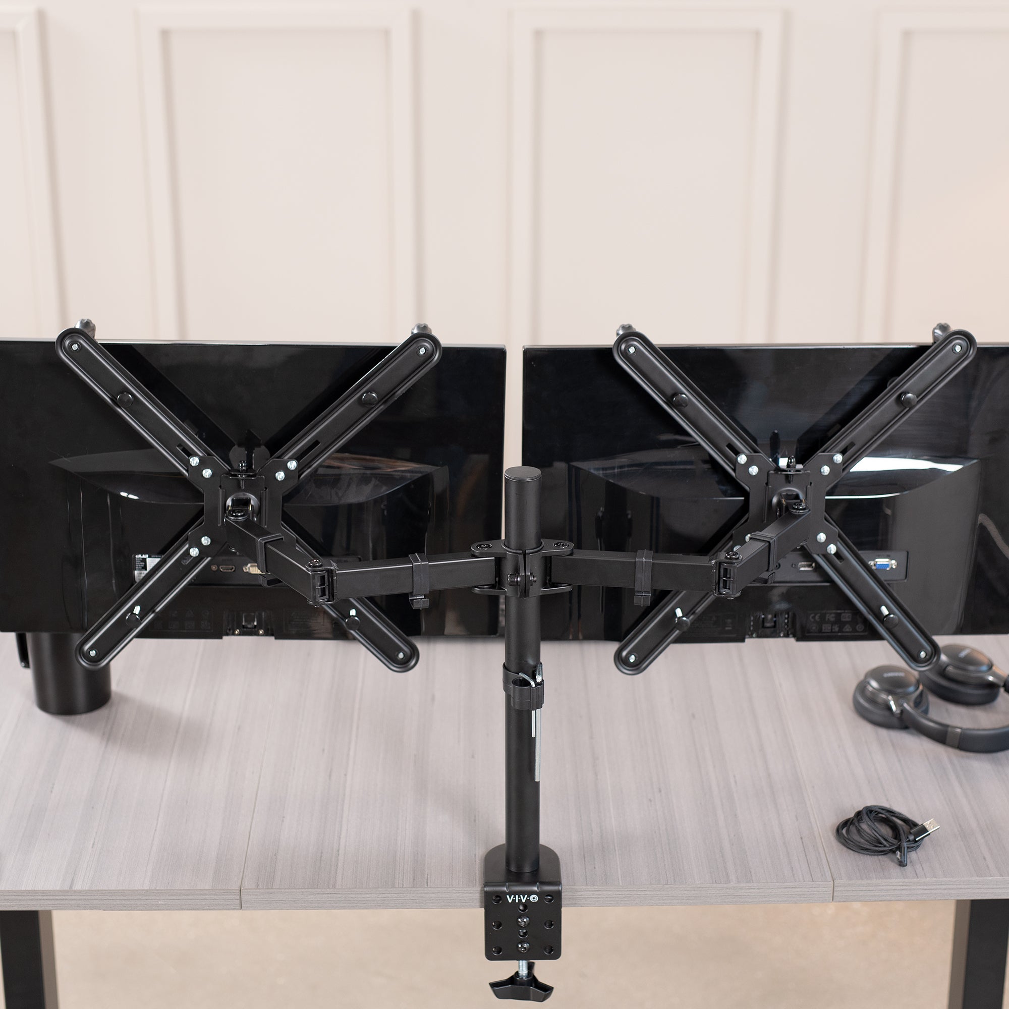 Dual Monitor Desk Mount with VESA Adapter Bracket mounted on desk in office setting.