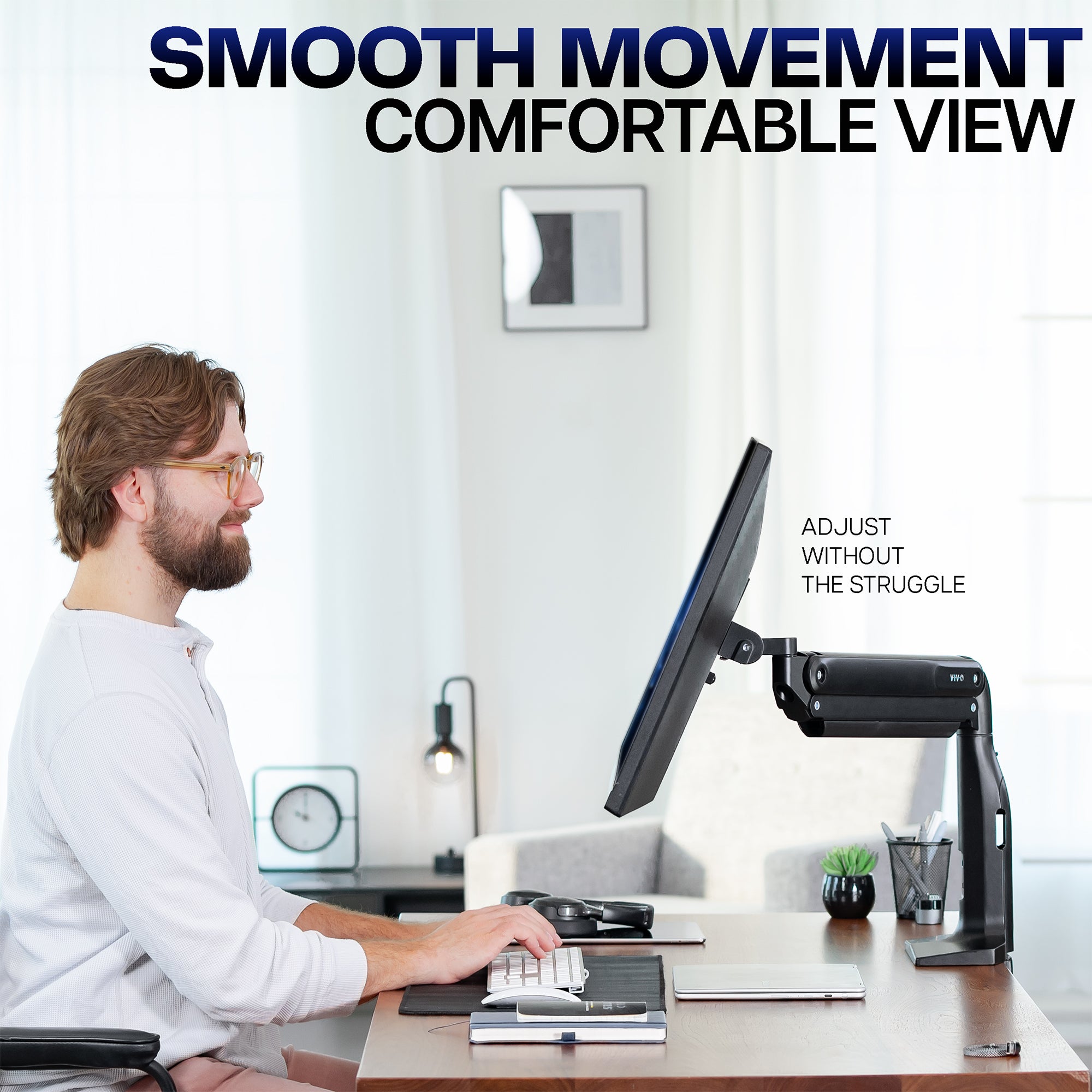 Man using a computer with a monitor stand in a home office setting