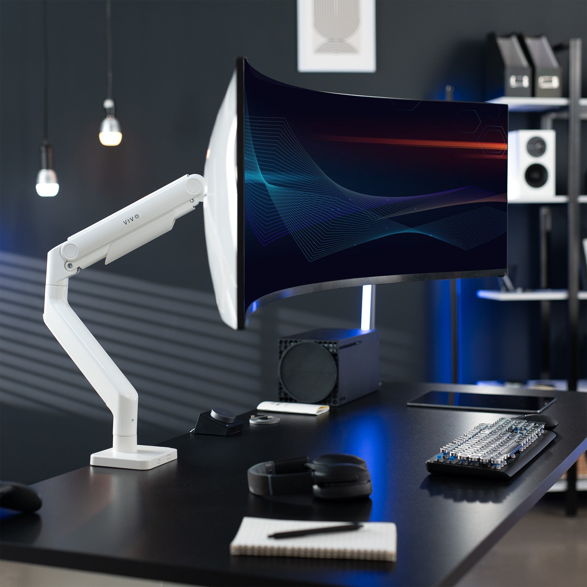 A single ultrawide computer monitor attached to a pneumatic arm desk mount