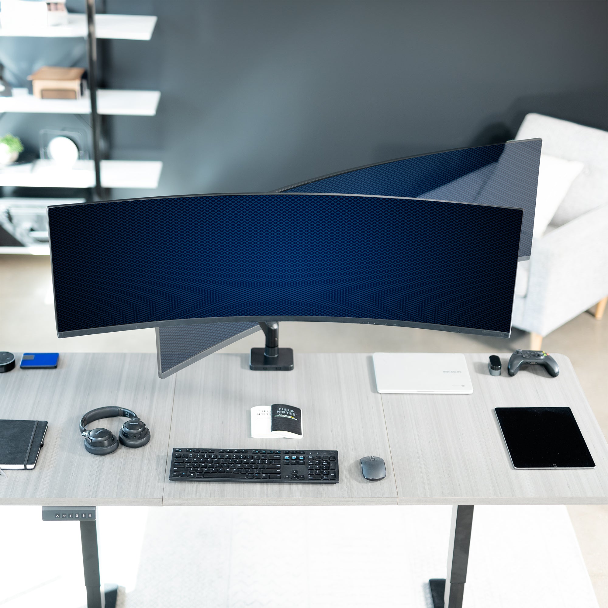 A single ultrawide computer monitor attached to a pneumatic arm desk mount with swiveling capability.