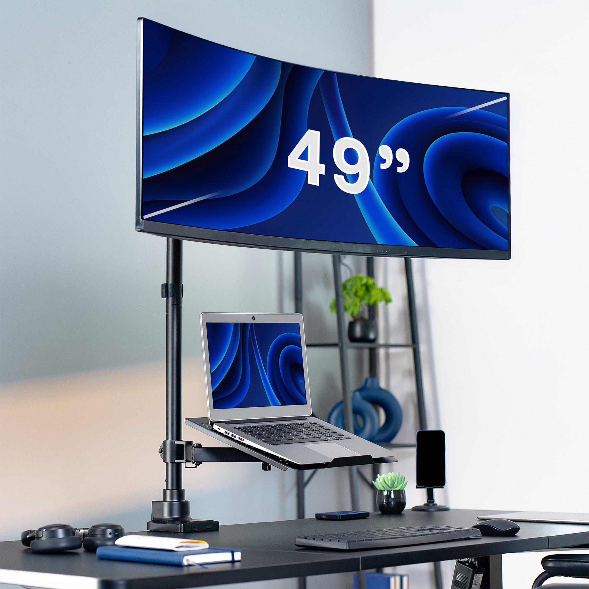 49-inch curved monitor on a stand with a laptop below, in an office setting.