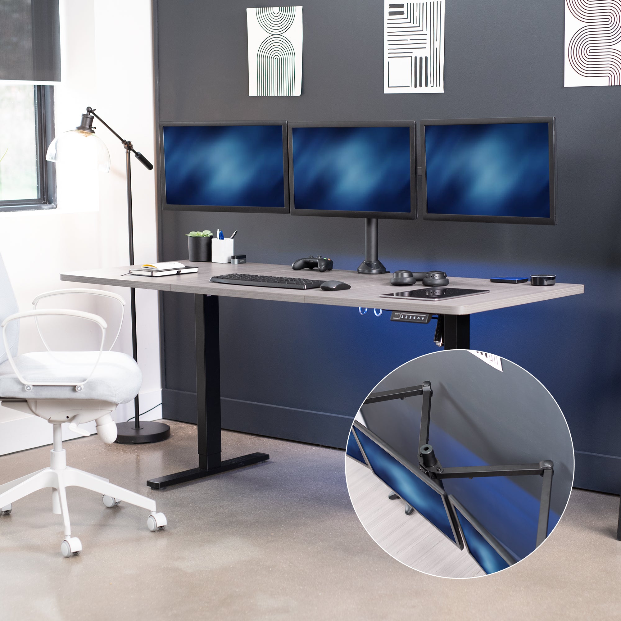 Modern office setup with a standing desk, computer monitors, and white chairs.