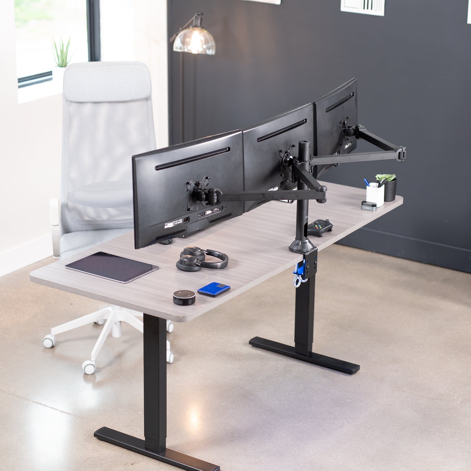 Modern office setup with a adjustable desk and dual monitor stand.