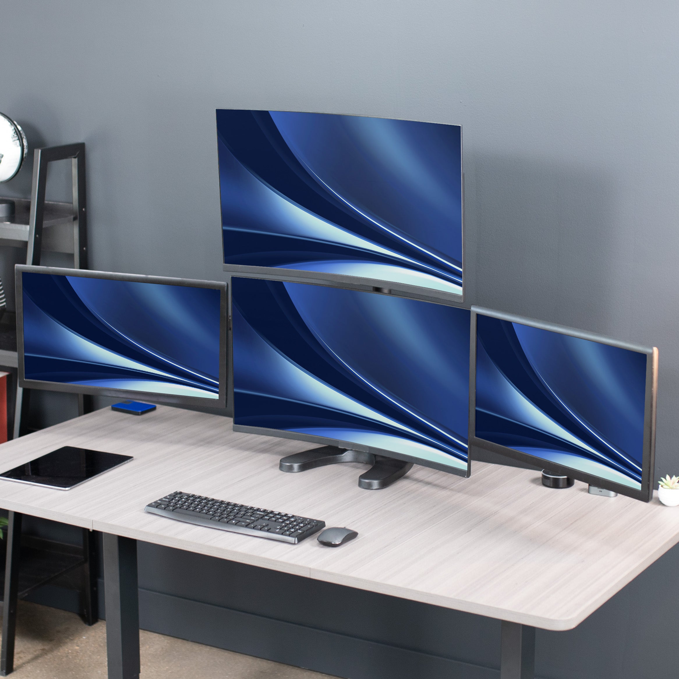 Quad Monitor Desk Stand on desk in office space.
