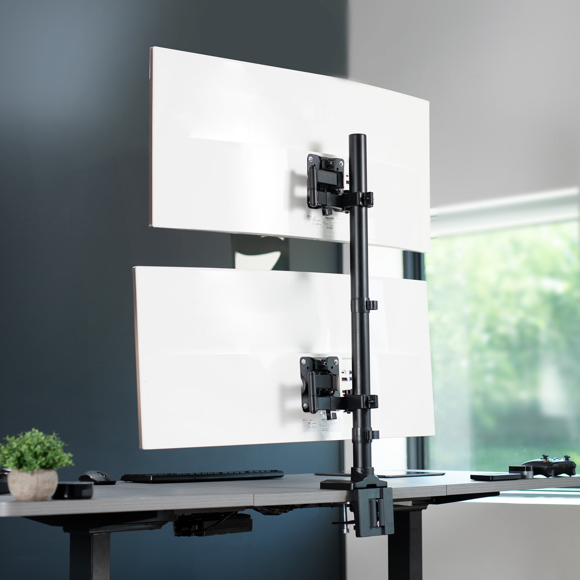 Stacked vertical dual monitor ultrawide desk mount with extending arms. Height adjustable with tilt, swivel, and integrated cable management.