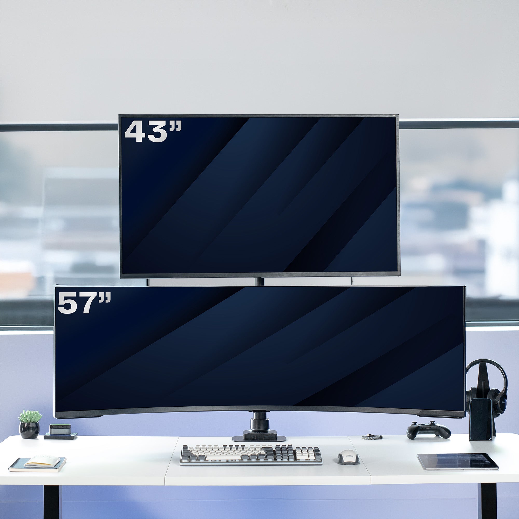 Two computer monitors of different sizes on a desk with a blurred office background