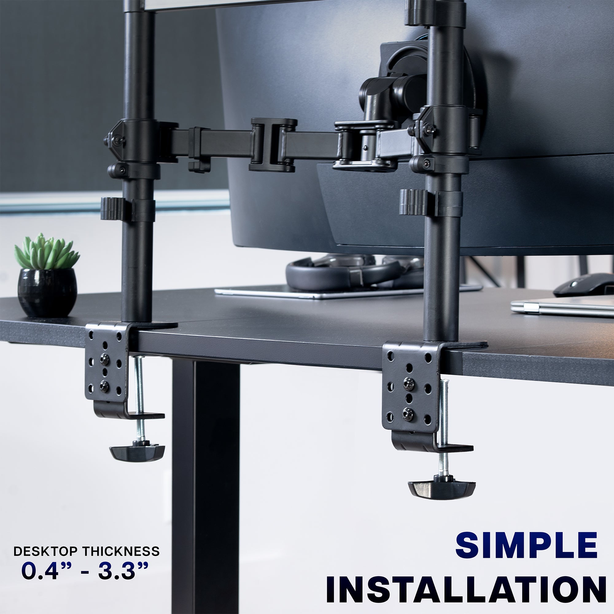 Monitor stand with "C" clamps on a desk, featuring text about desktop thickness and installation.