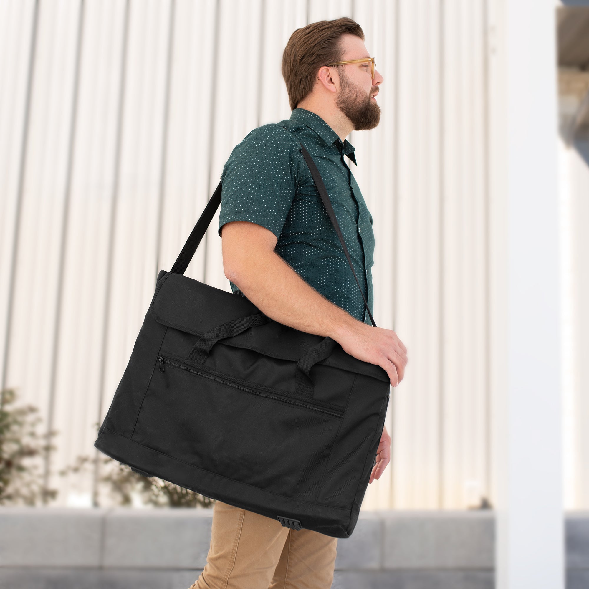 A black monitor travel case with a shoulder strap and multiple compartments.
