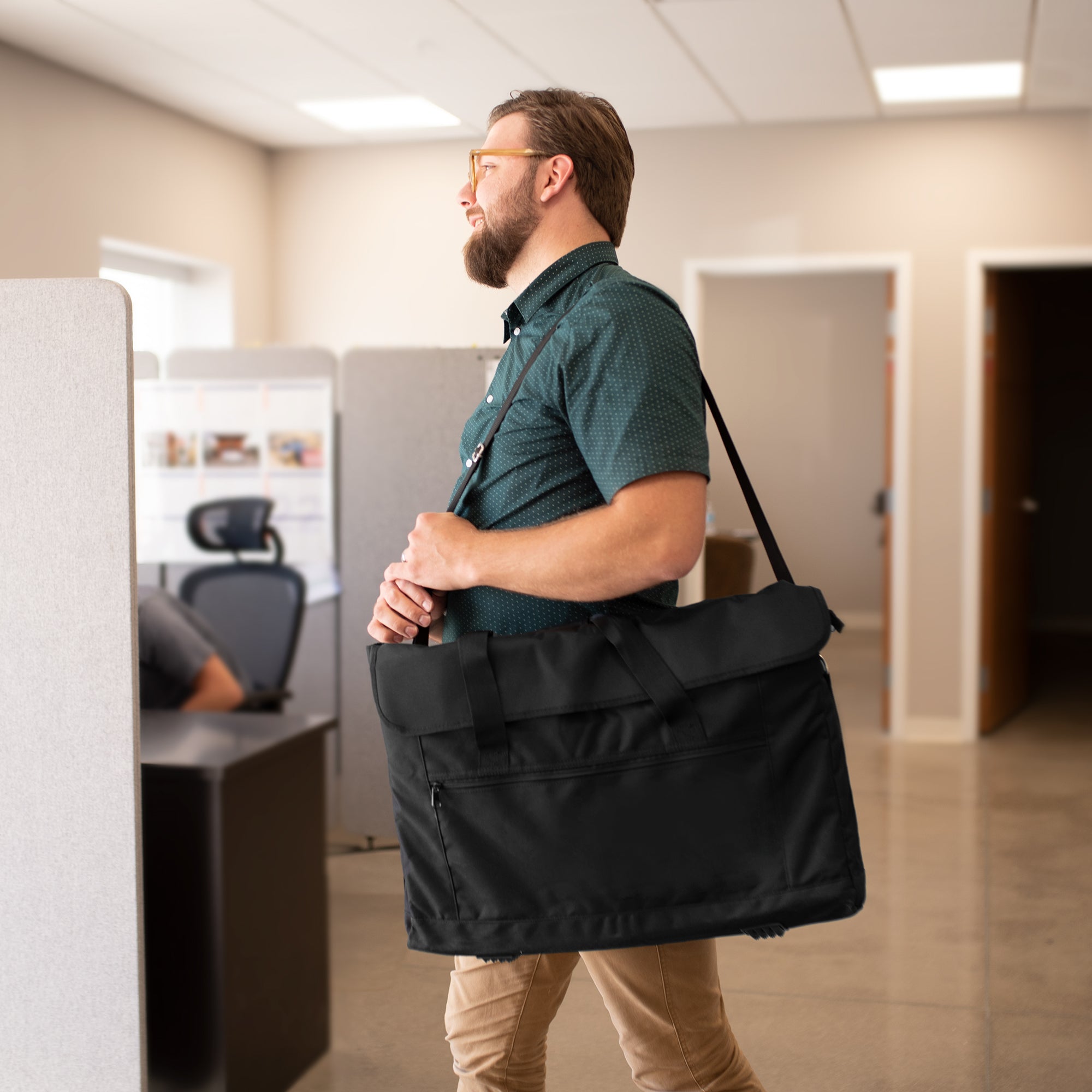 A black monitor travel case with a shoulder strap and multiple compartments.