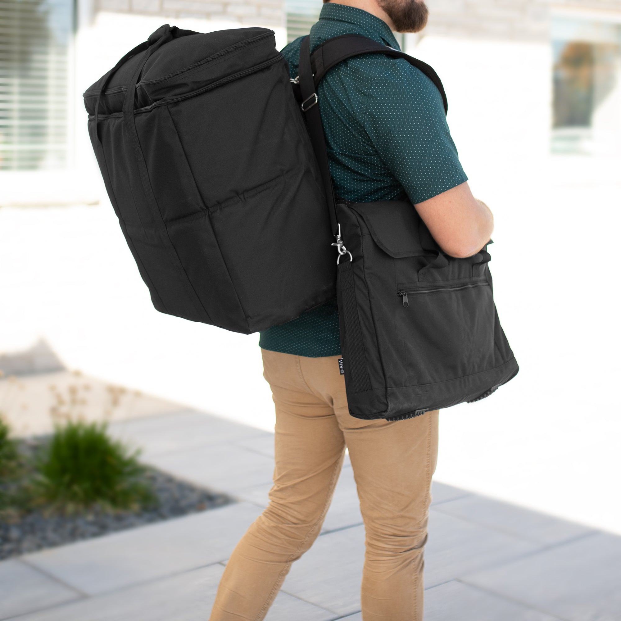 A black monitor travel case with a shoulder strap and multiple compartments.