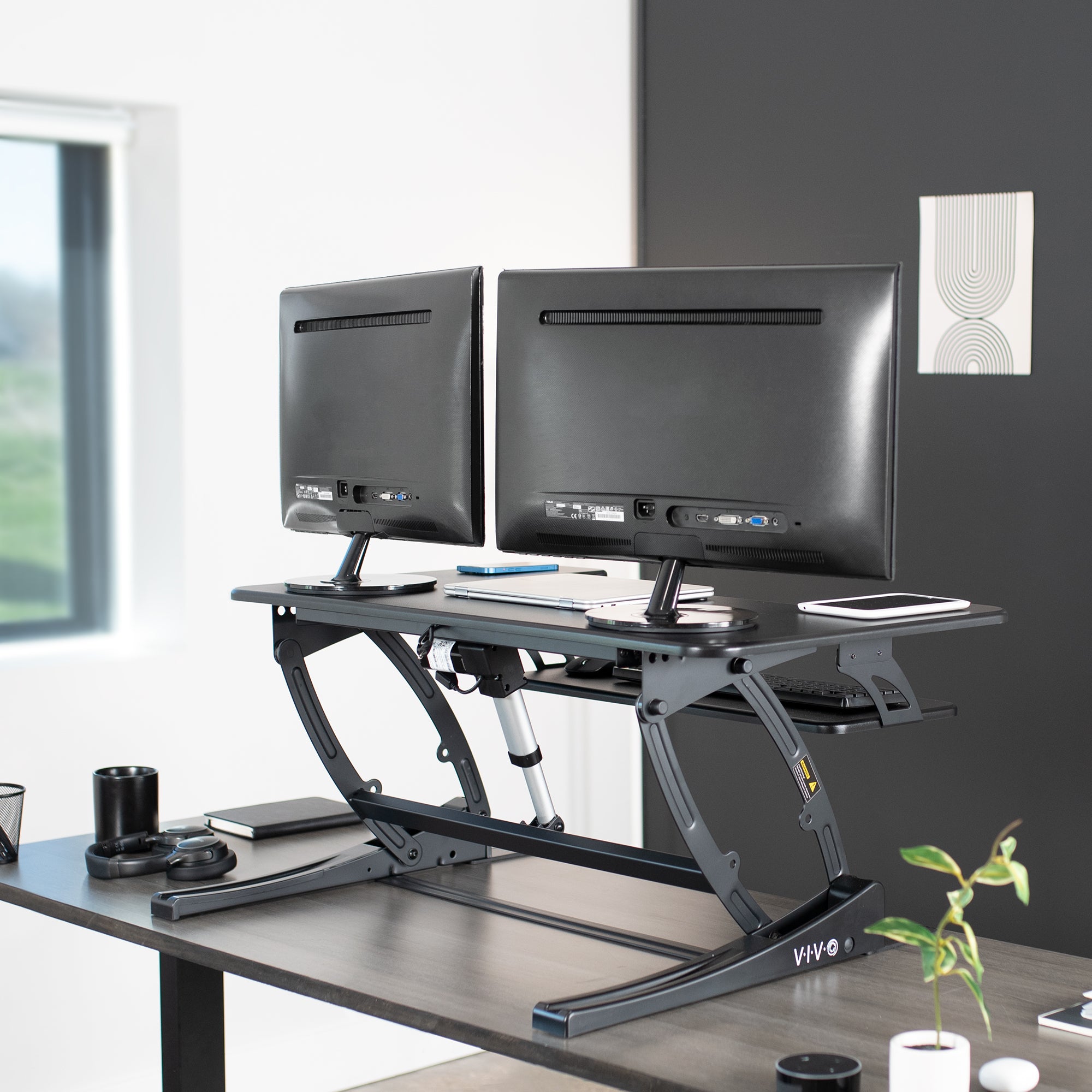 Dual-tiered, electric desk riser that sits on top of your current desk and gives you the benefit of standing up throughout the work day.