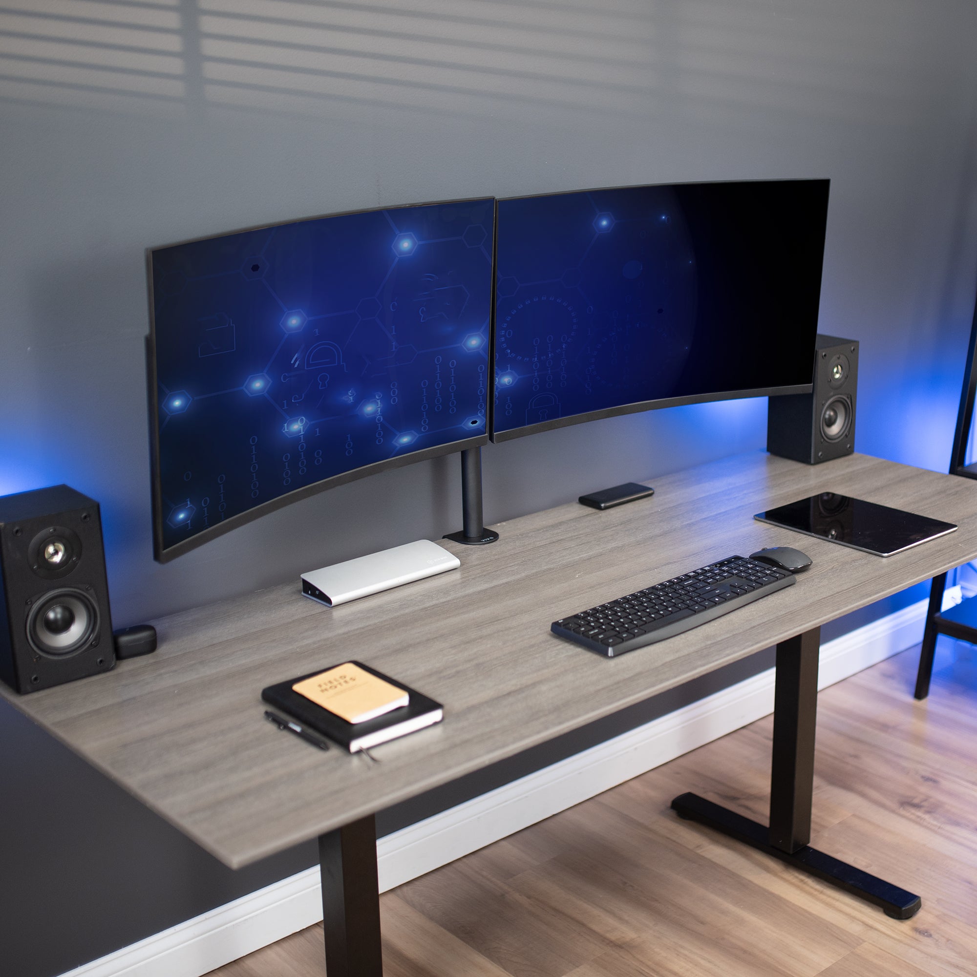 Dual monitor mount on desk in office setting.