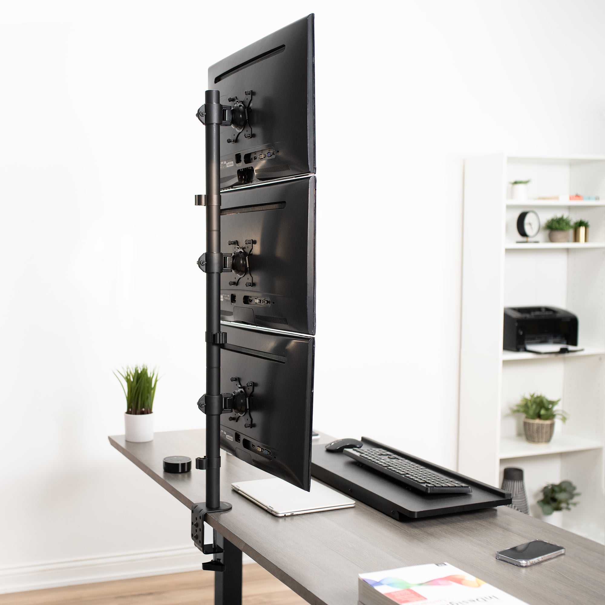 Triple Vertical Monitor Desk Mount on desk in office setting.
