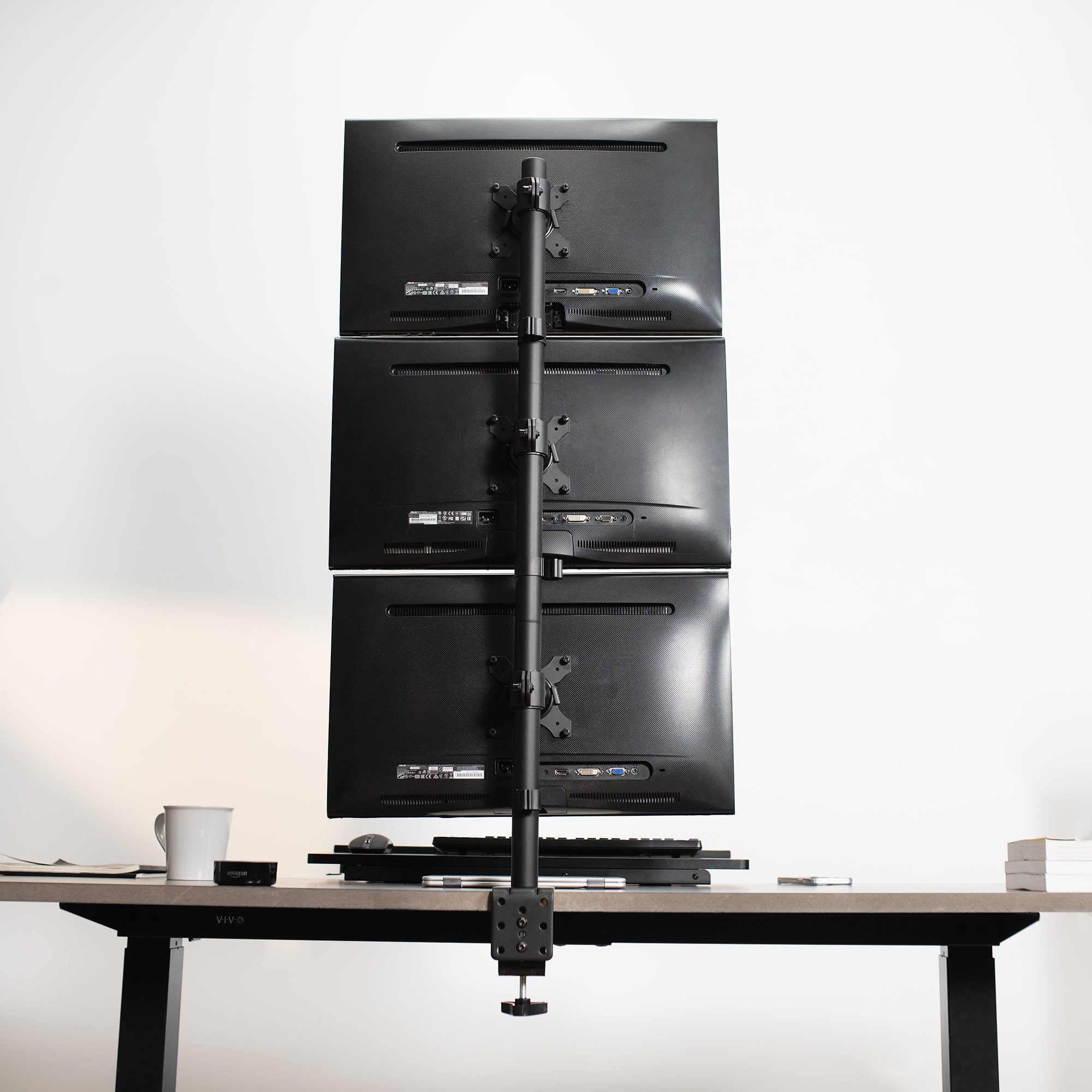 Triple Vertical Monitor Desk Mount in office setting.