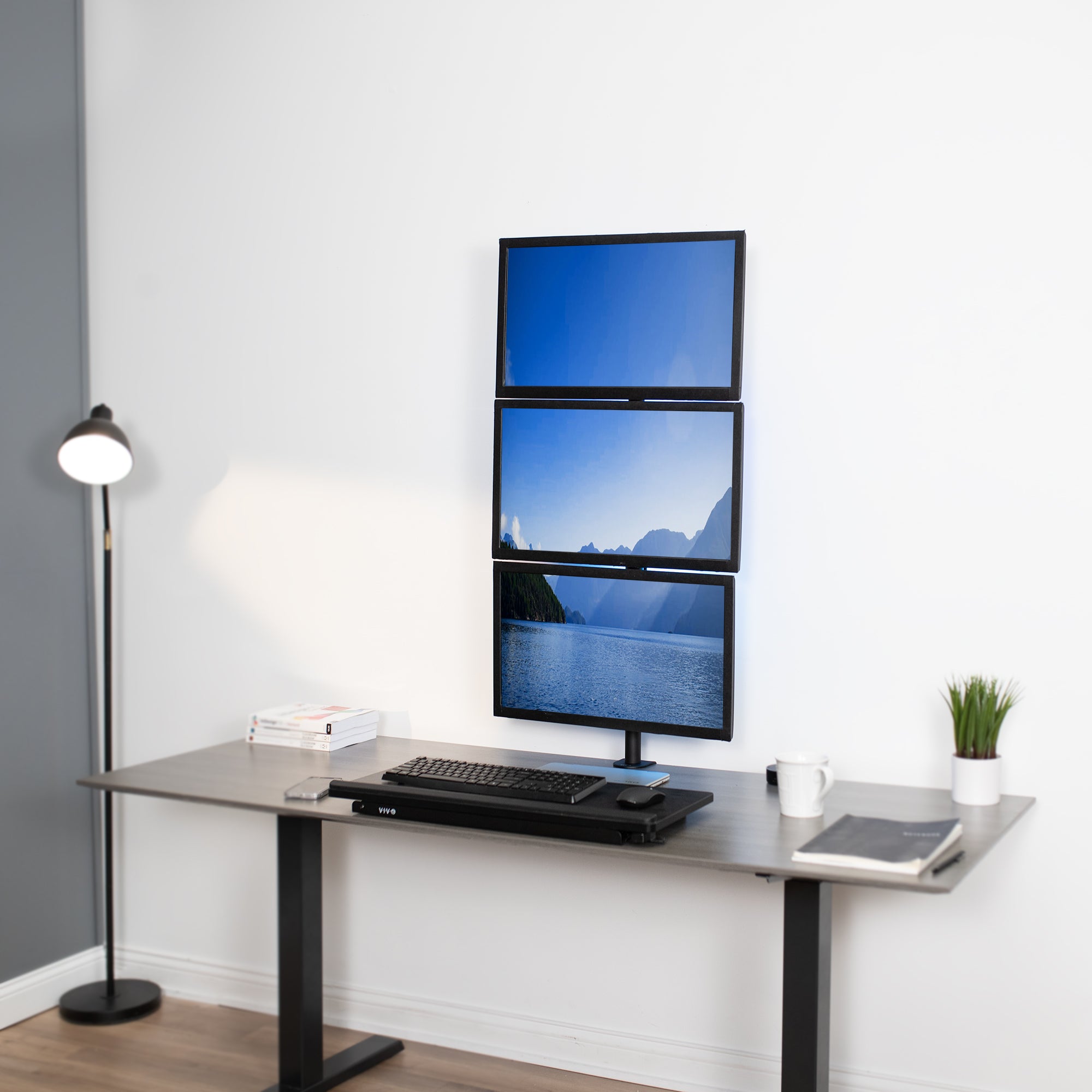 Triple Vertical Monitor Desk Mount in office setting.