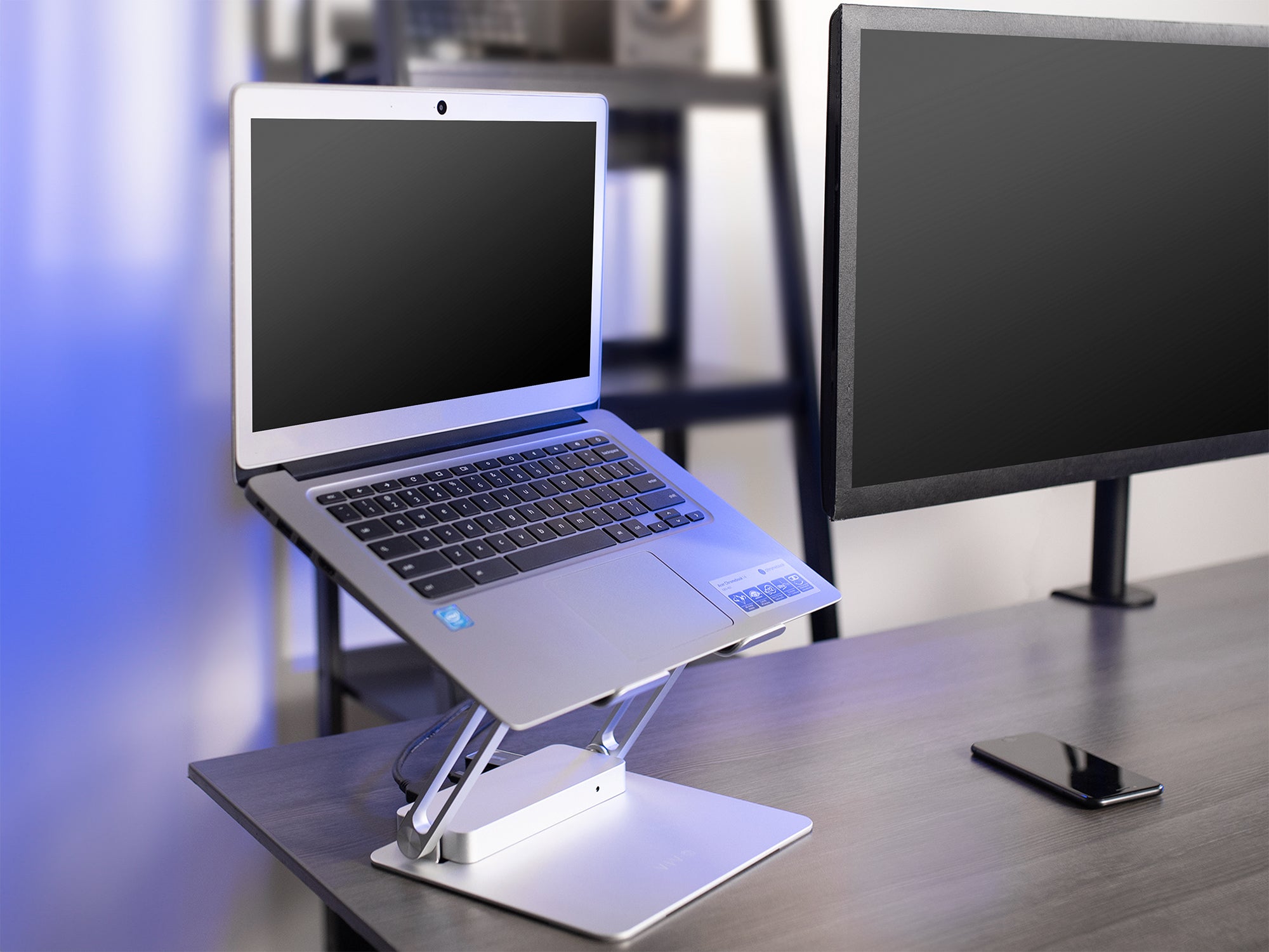 laptop stand on desk next to monitor mount