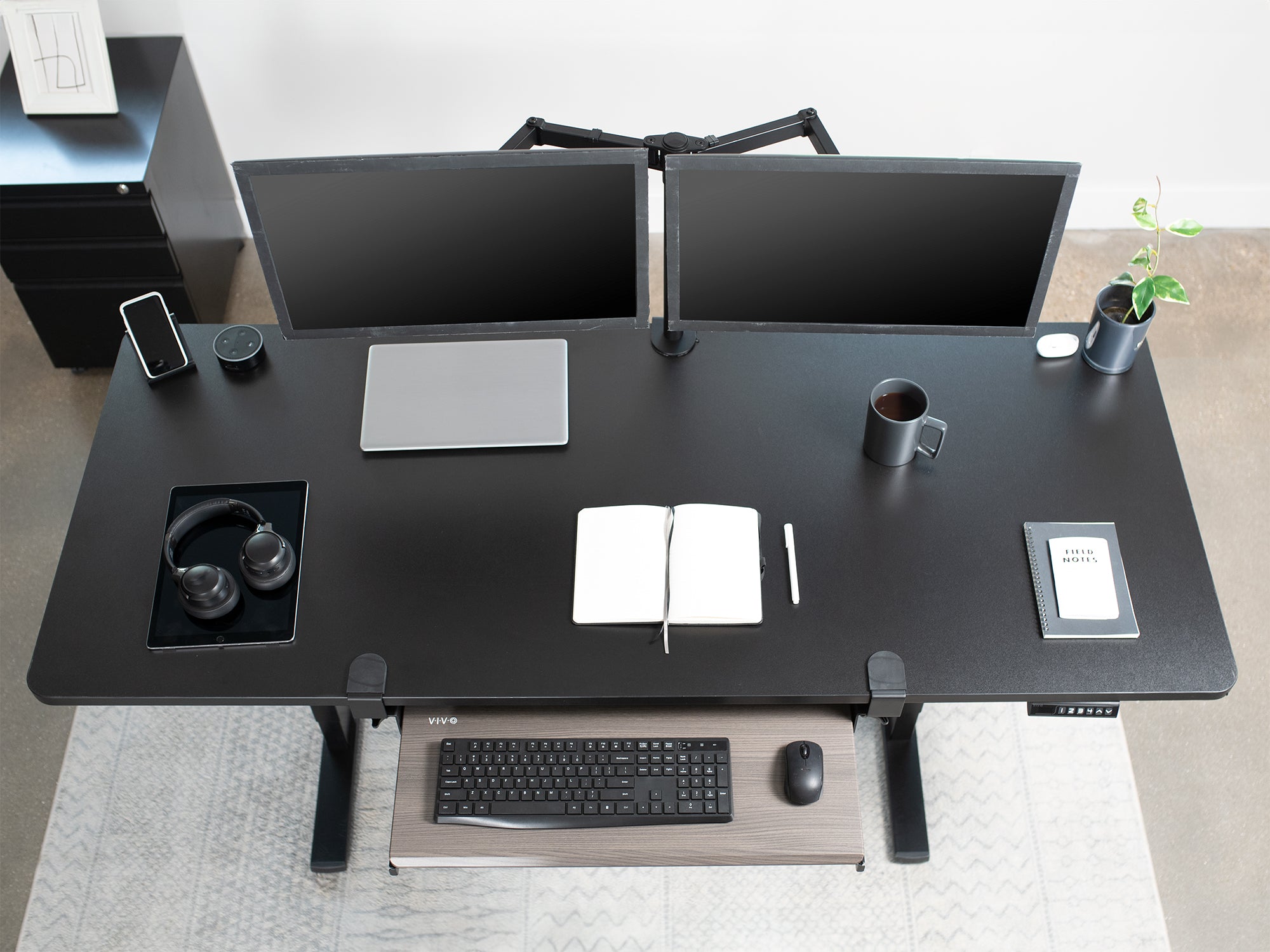 black electric desk with dual monitor mount and keyboard tray for added ergonomics