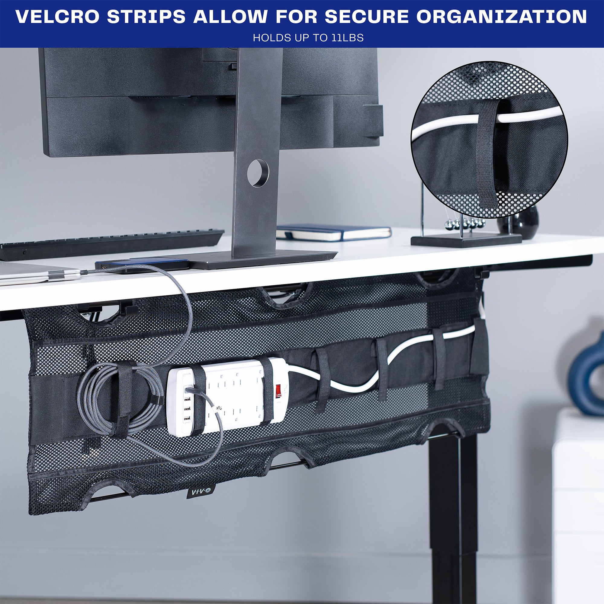 A black mesh cable management system with a power strip with Velcro strips for organization. 