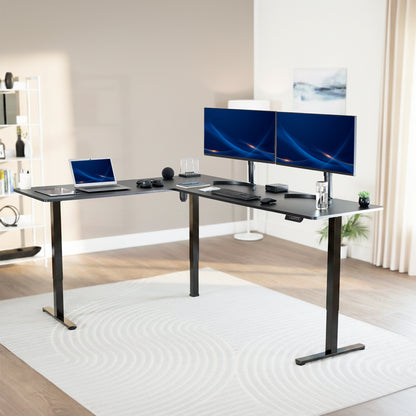 Modern office setup with a black L-shaped desk, dual monitors, and a laptop.