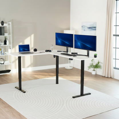 Modern home office with a white L-shaped desk, laptop, and two monitors.